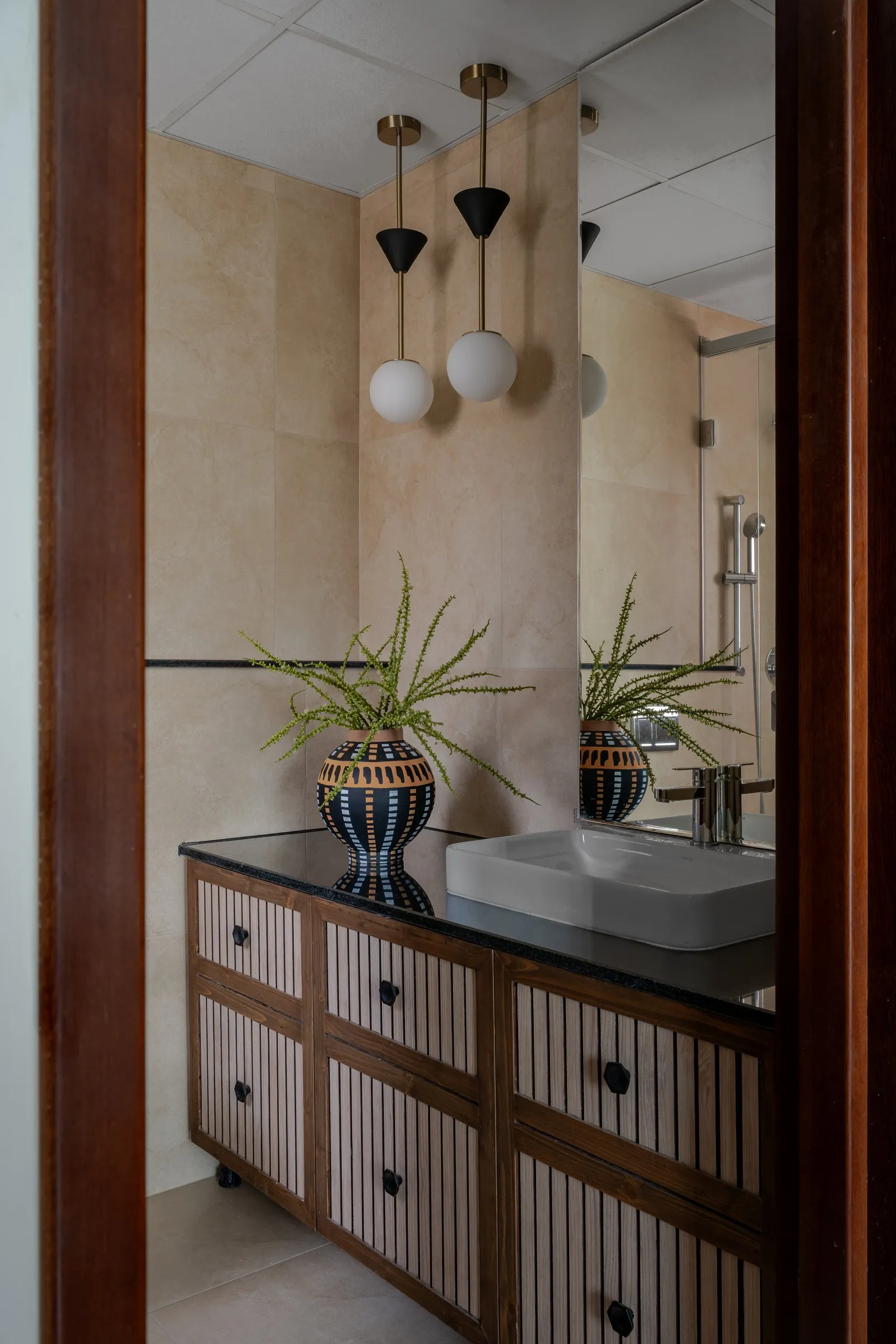 Bathroom vanity with striped drawers and glass globe pendants