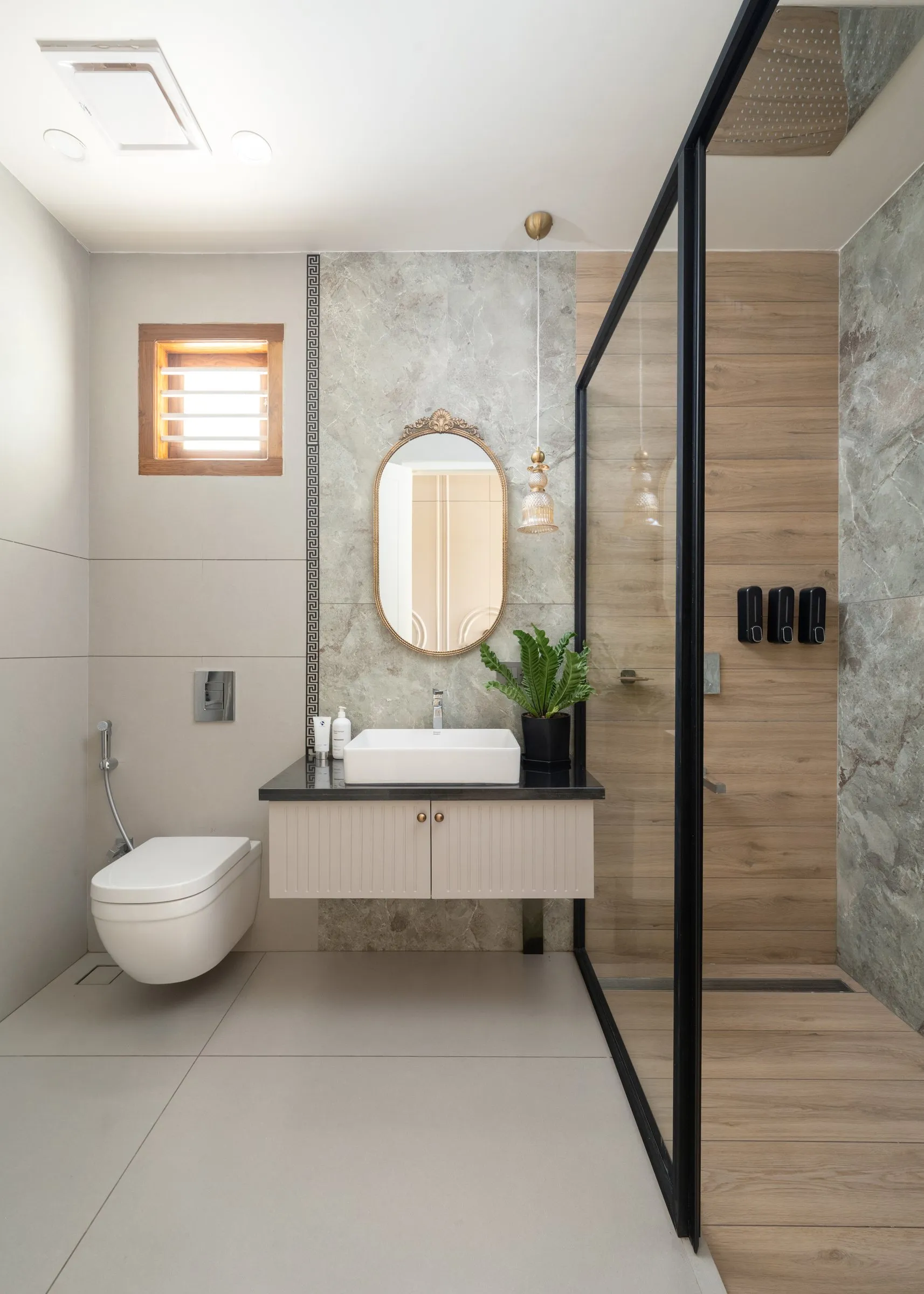 Bathroom with an oval mirror and a black-framed glass shower