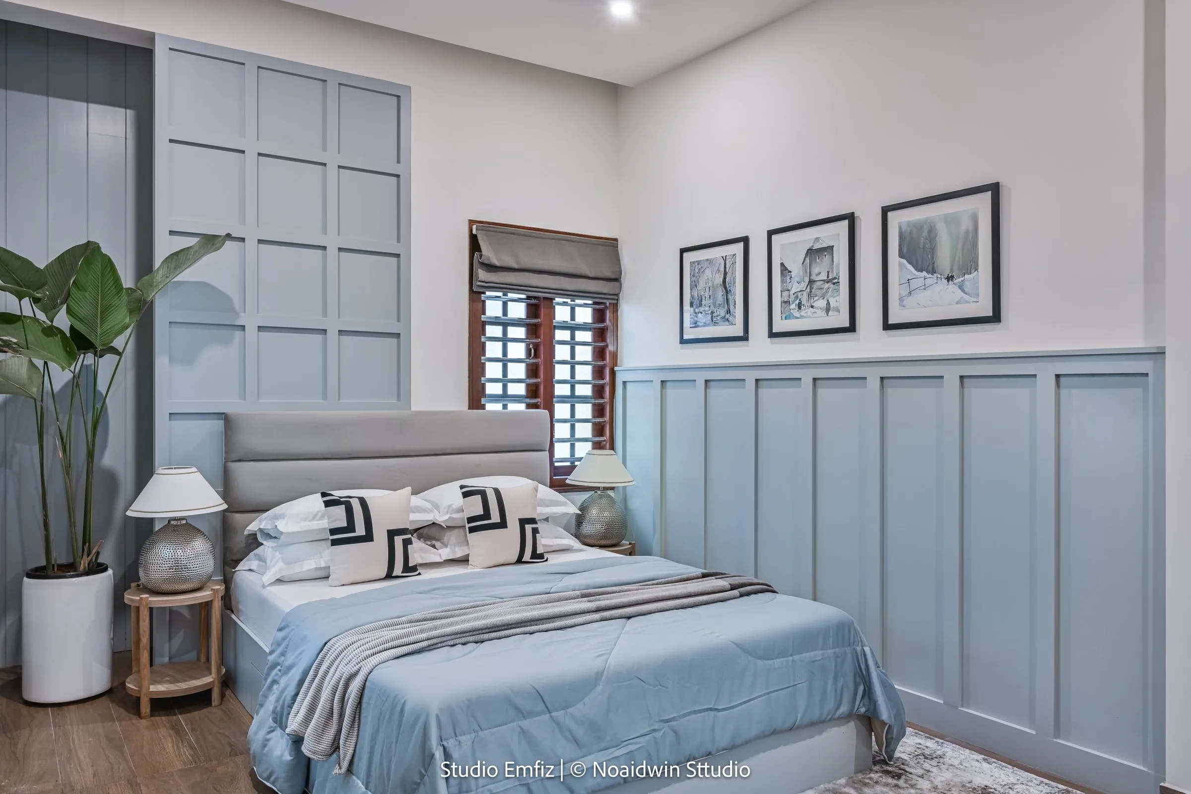 Bedroom with powder-blue panelled walls and framed prints