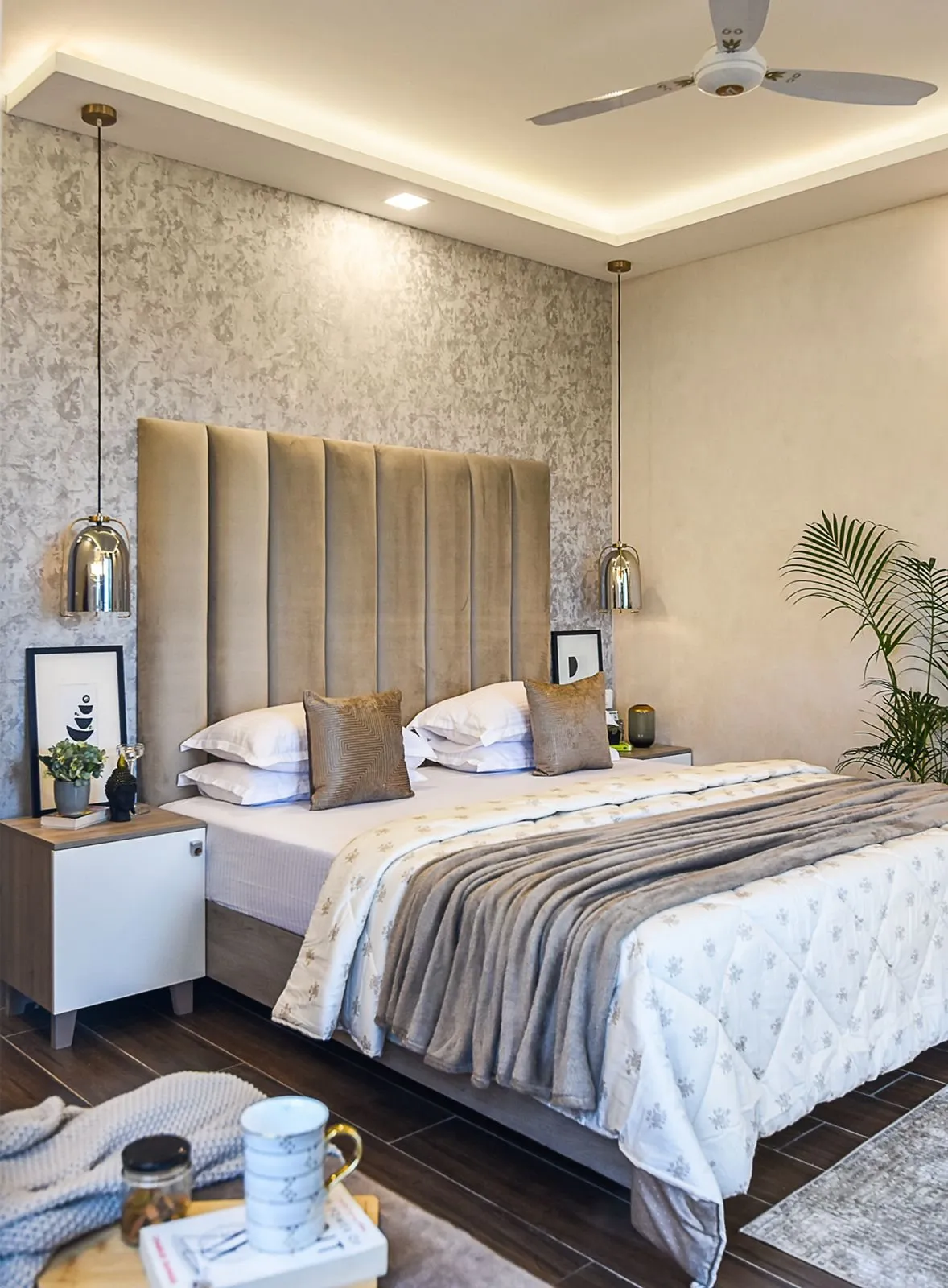 Bedroom with a tall padded headboard and textured wallpaper