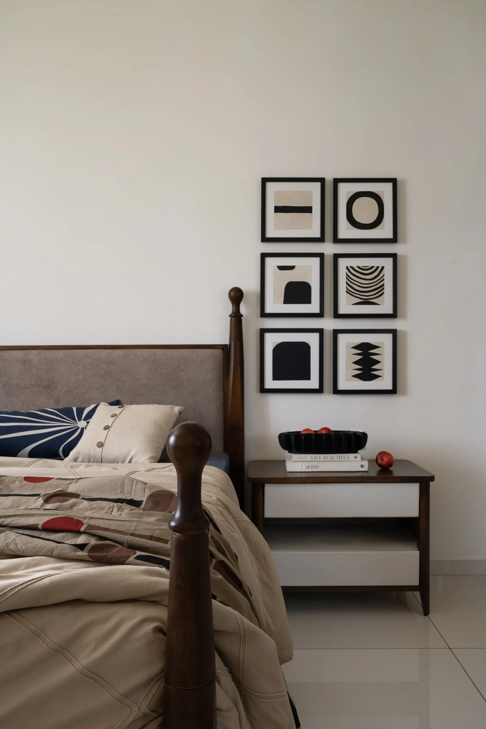 Main bedroom with a grid of black and white artwork above the bed