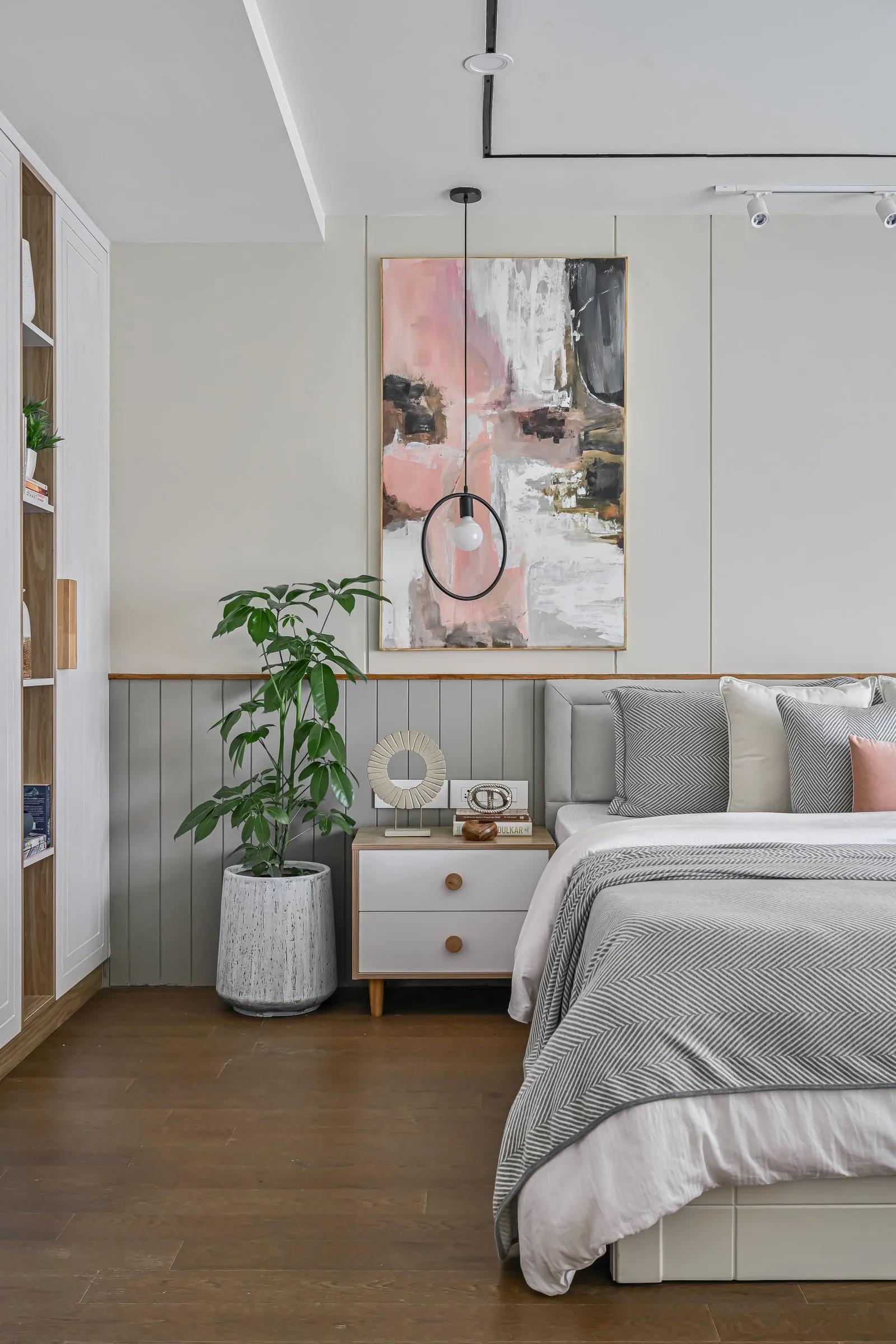 Bedroom with blush artwork and a ring pendant light