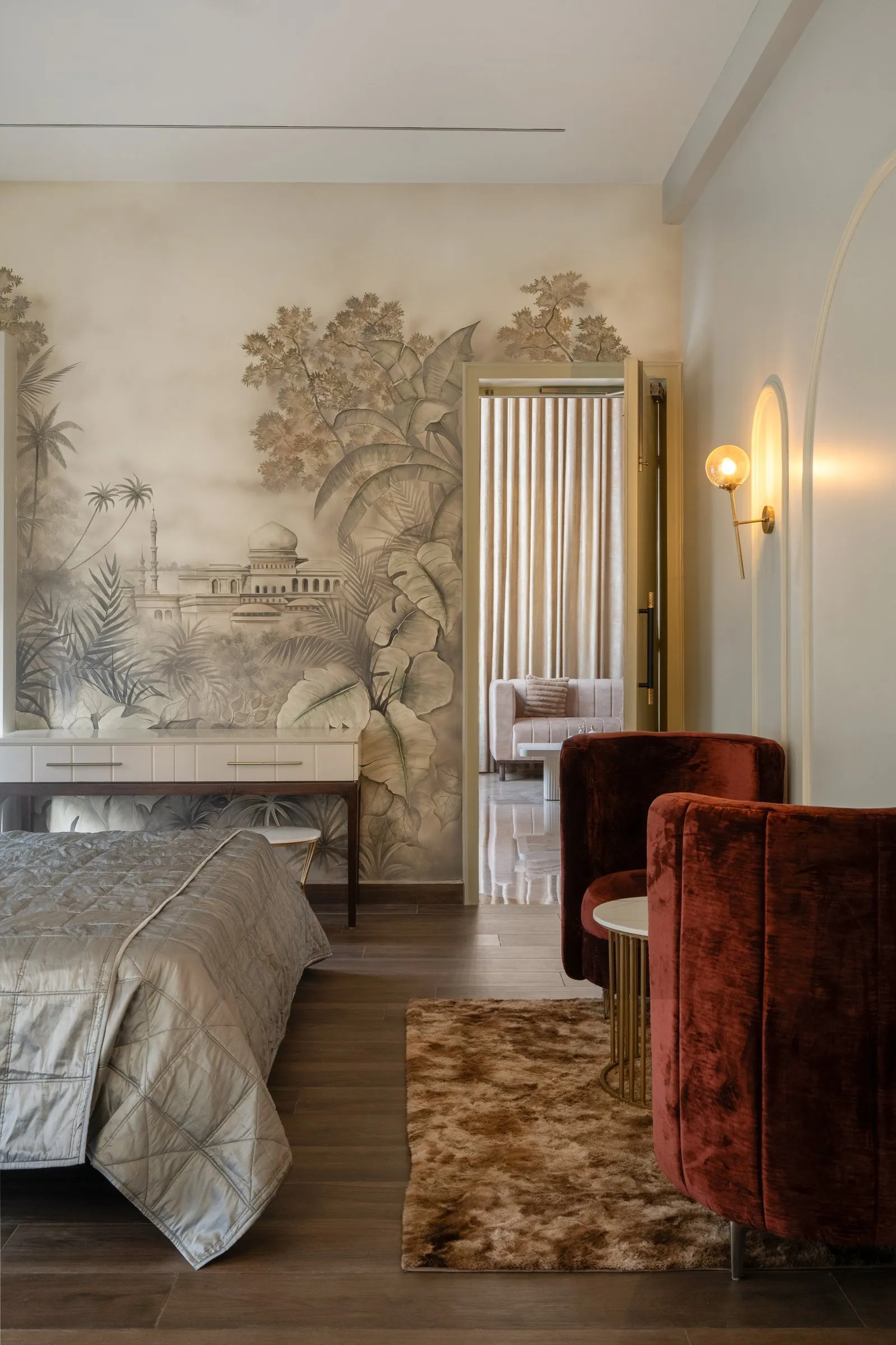 Bedroom with a painted garden mural and red velvet chairs