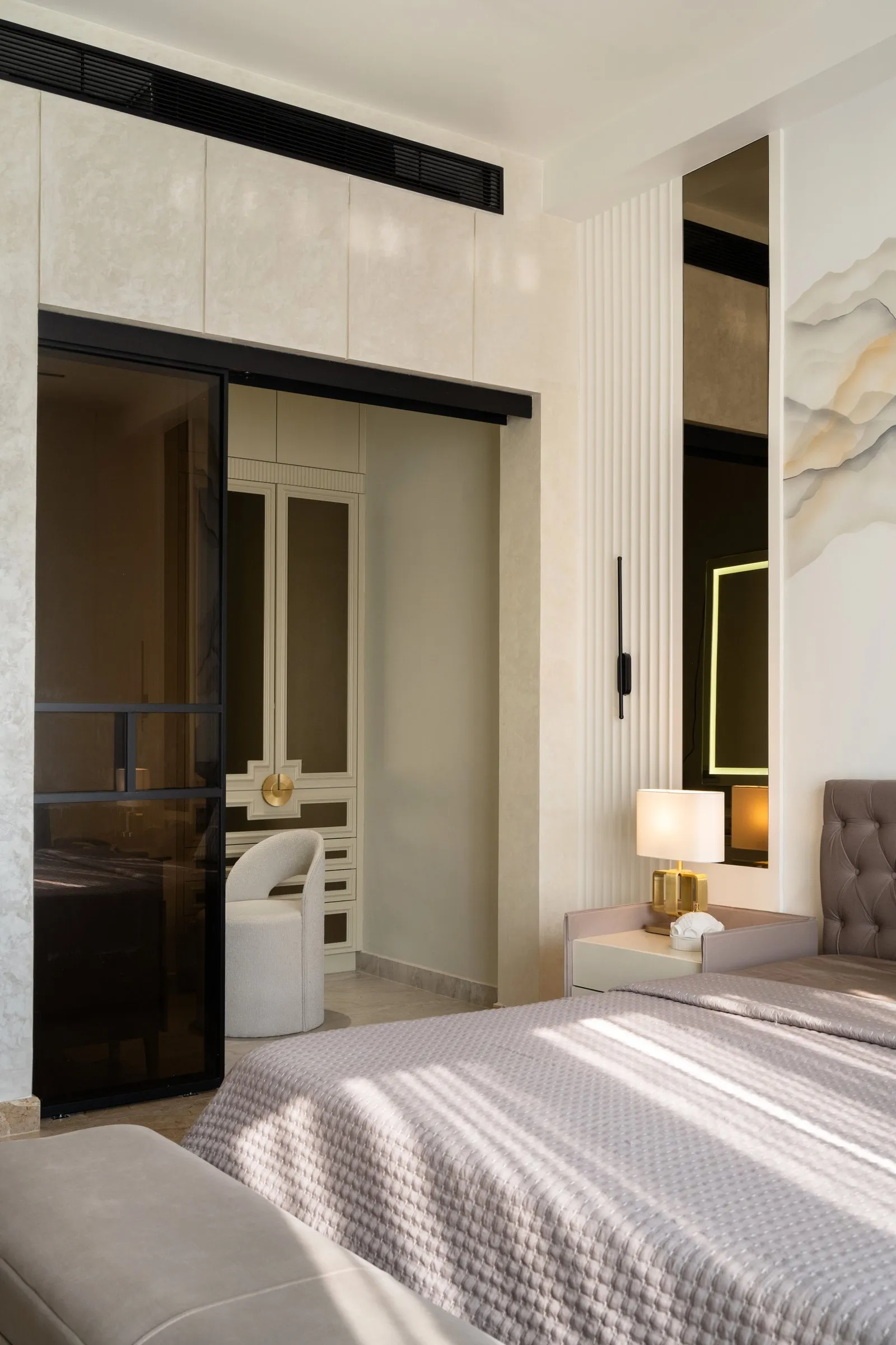 Bedroom with a marble wall and black glass wardrobe