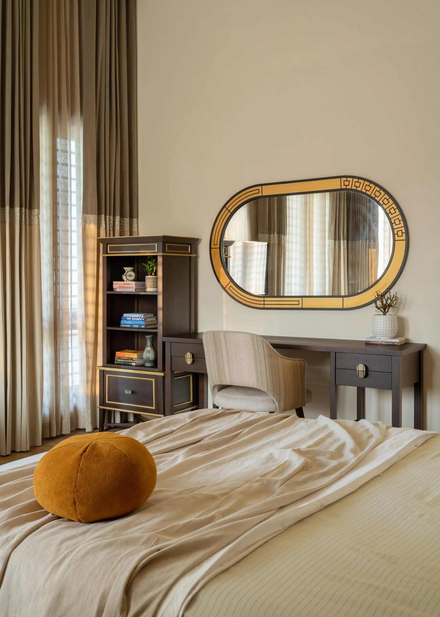 Bedroom with a gold oval mirror and a wooden cabinet