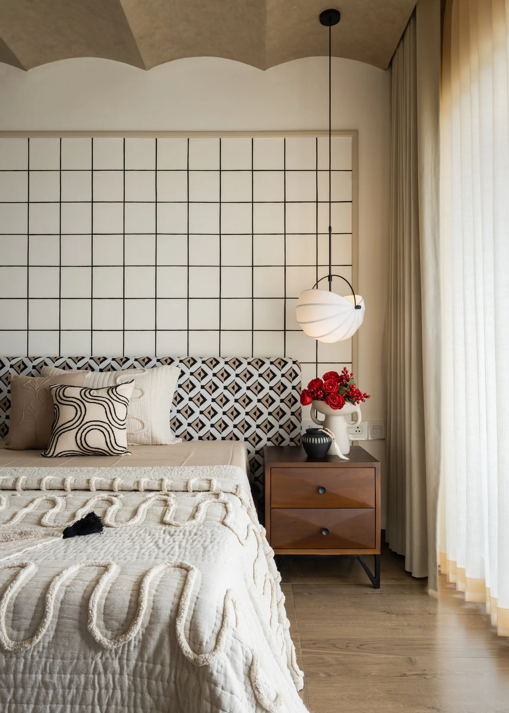 Main bedroom with a grid headboard wall and scalloped ceiling