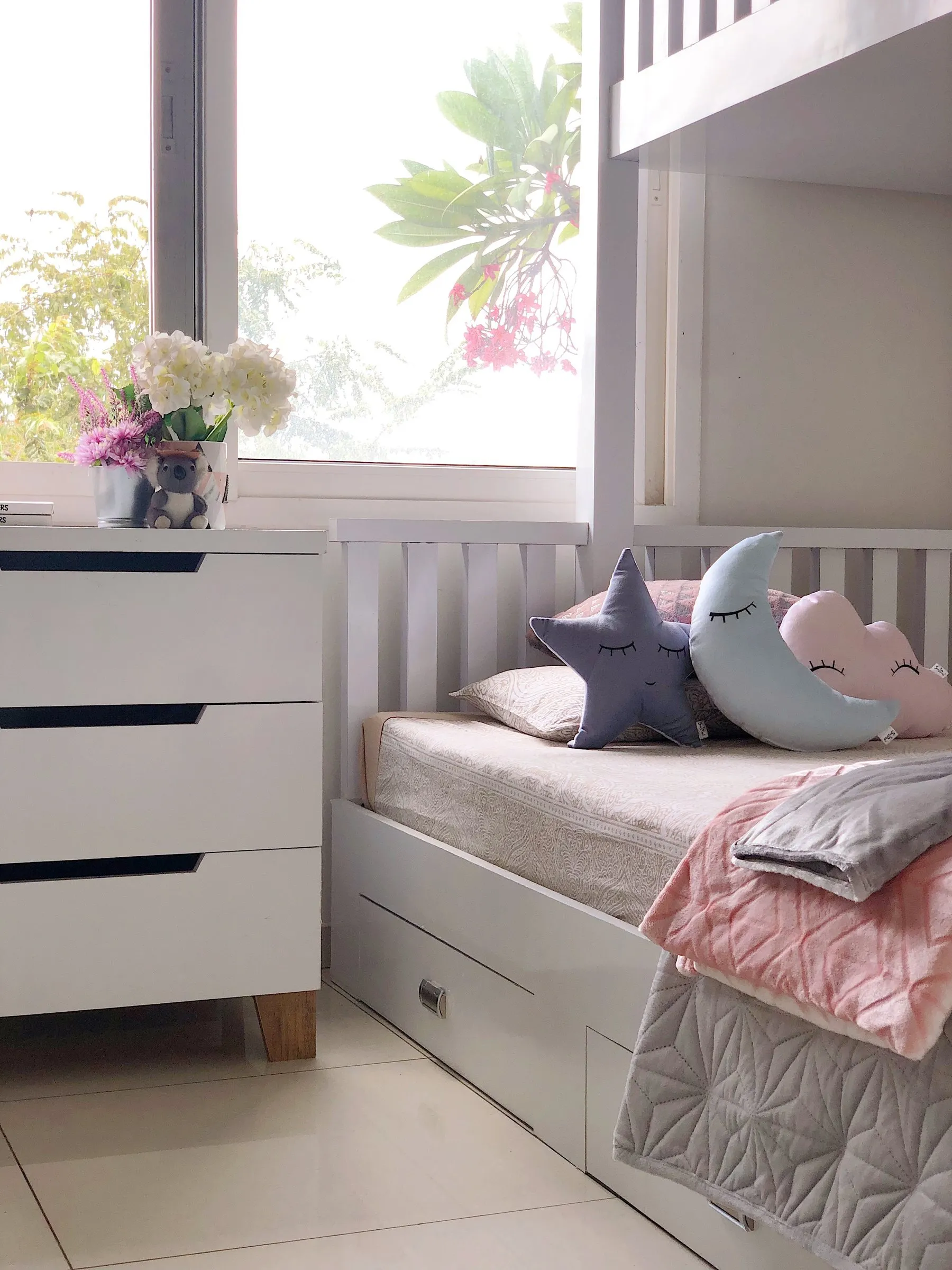 Child's room with a white bed and moon and star cushions