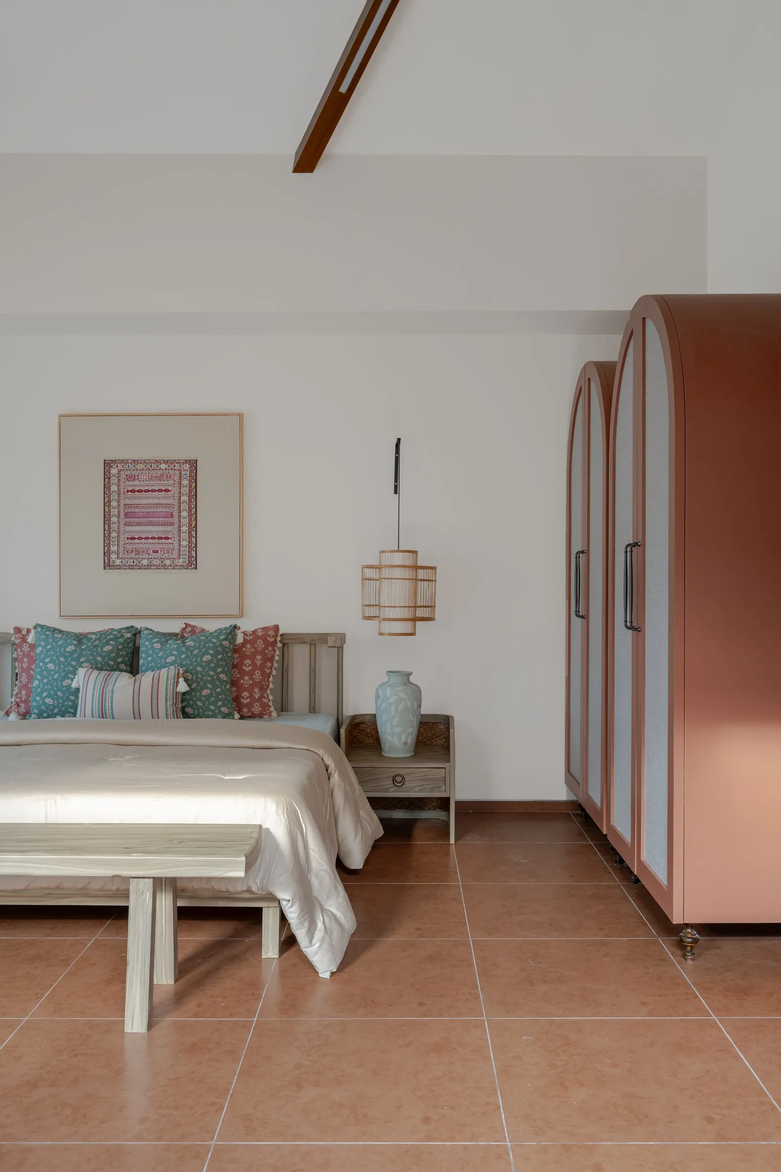 Bedroom with arched blush wardrobes and a framed textile