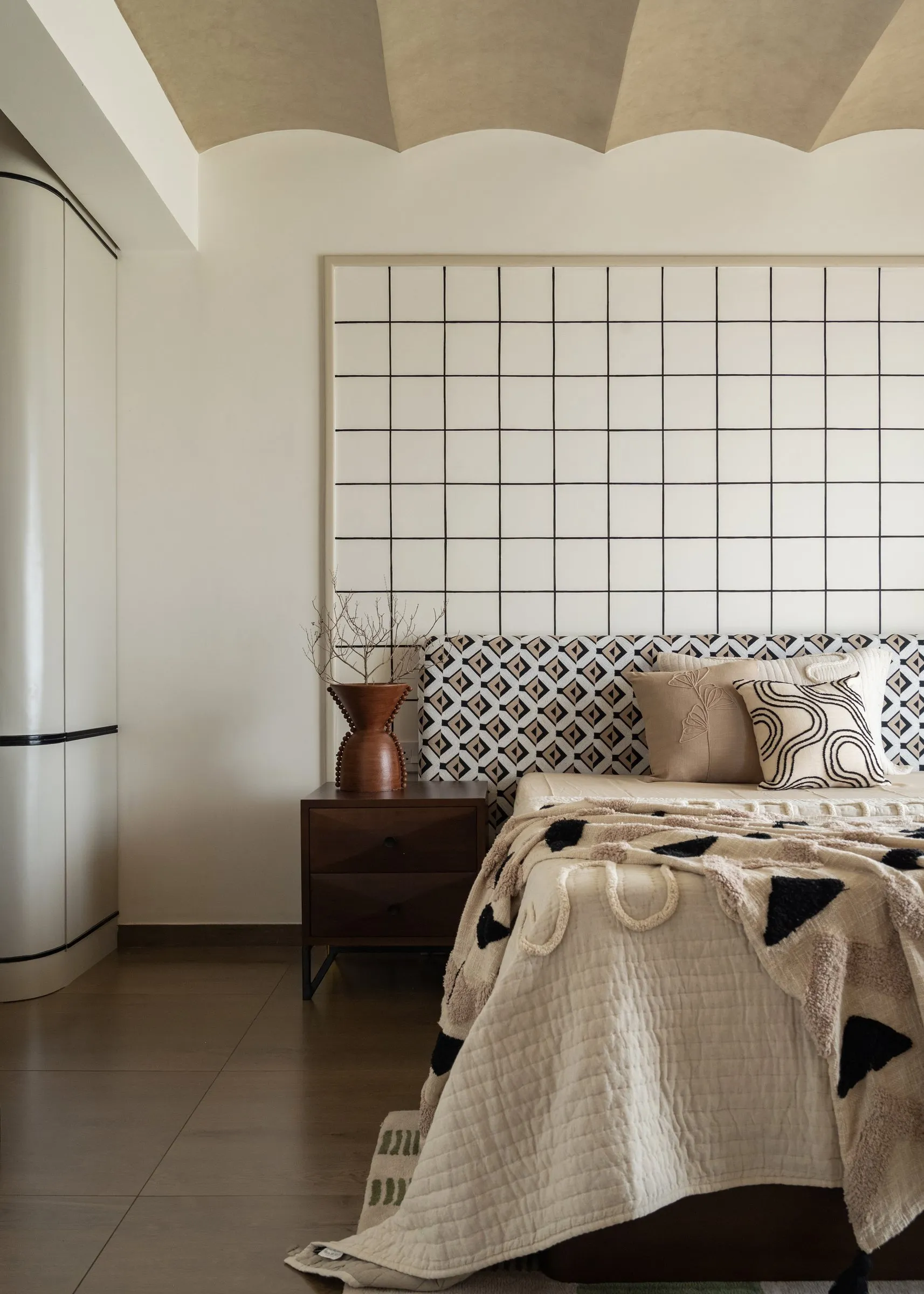 Main bedroom with a patterned headboard and graphic throw
