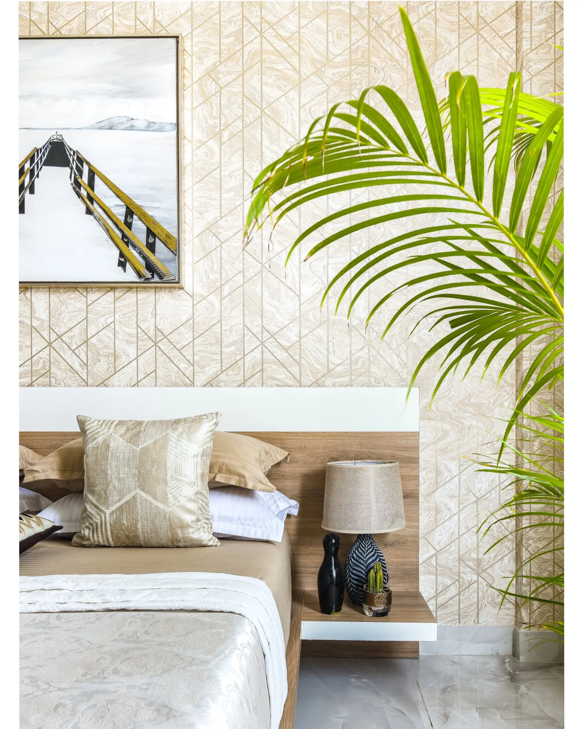 Bedroom with a geometric wallpaper and a gold cushion