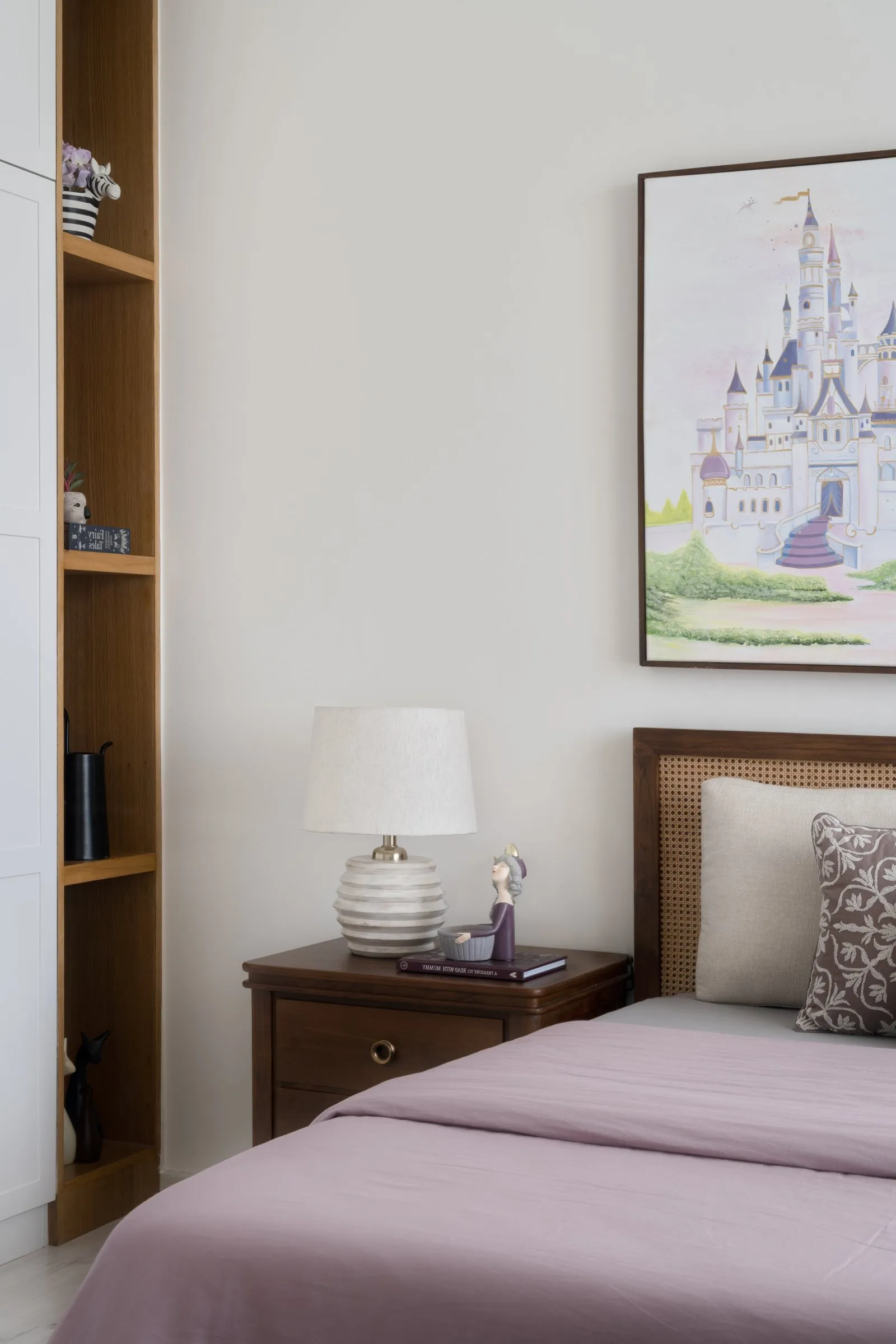 Child's bedroom with a castle painting and a cane headboard
