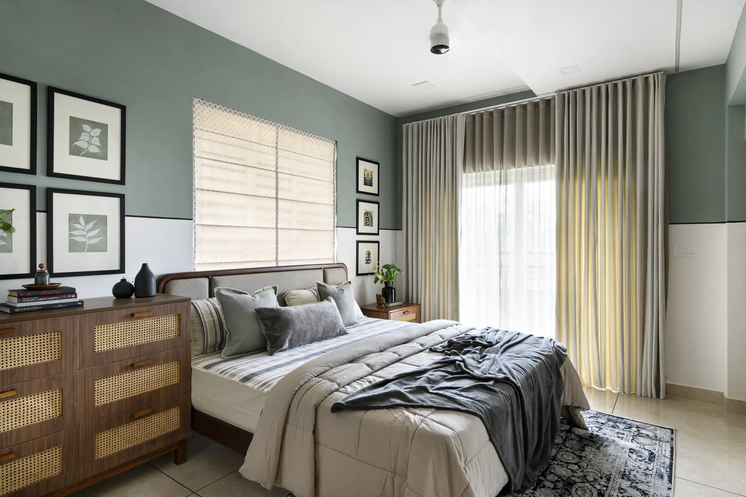 Bedroom with sage walls and a rattan chest of drawers
