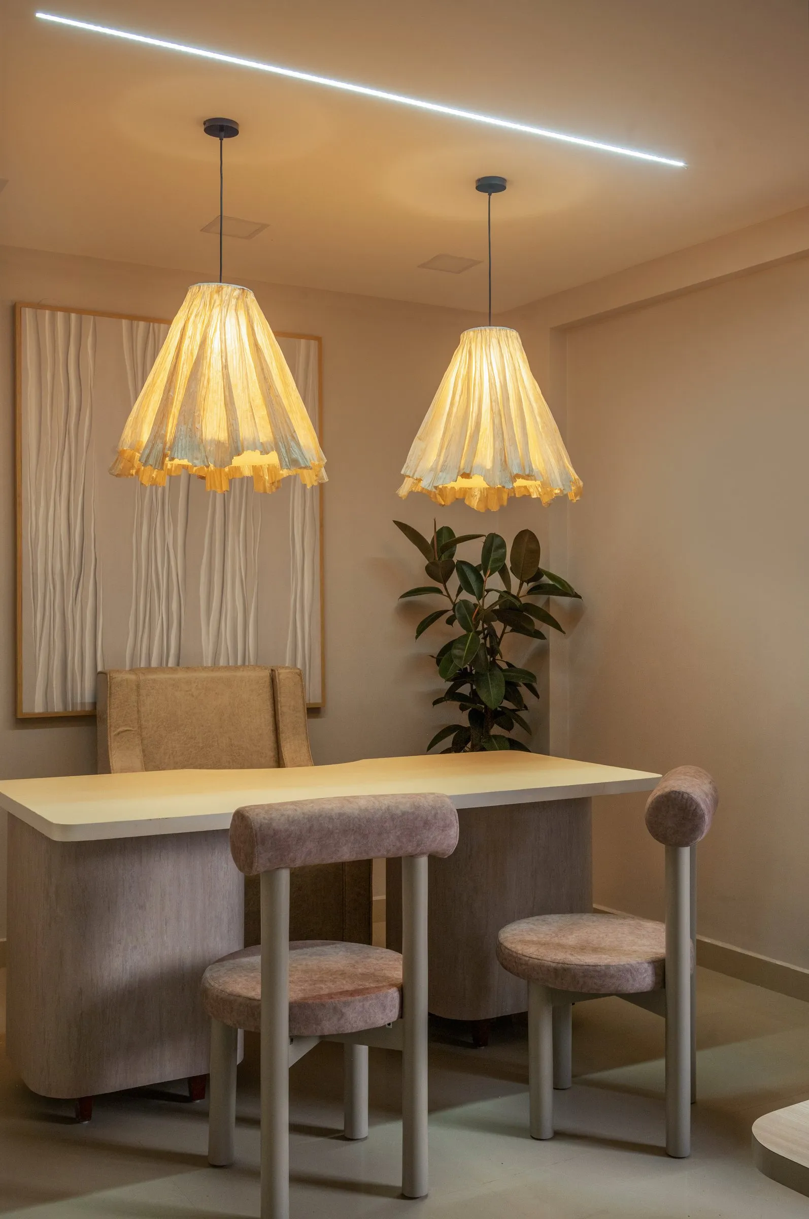 Consultation desk with blush stools and two pleated paper pendant lamps