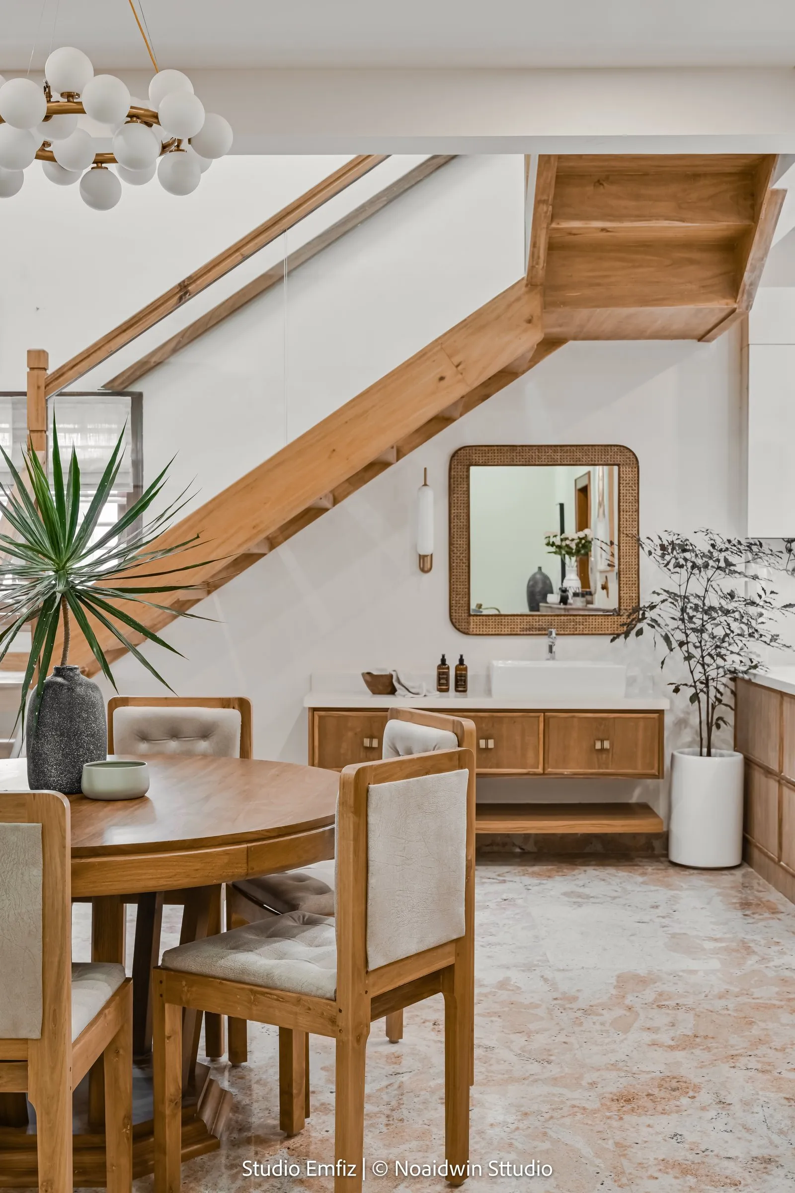 Round oak dining table beside an open oak staircase
