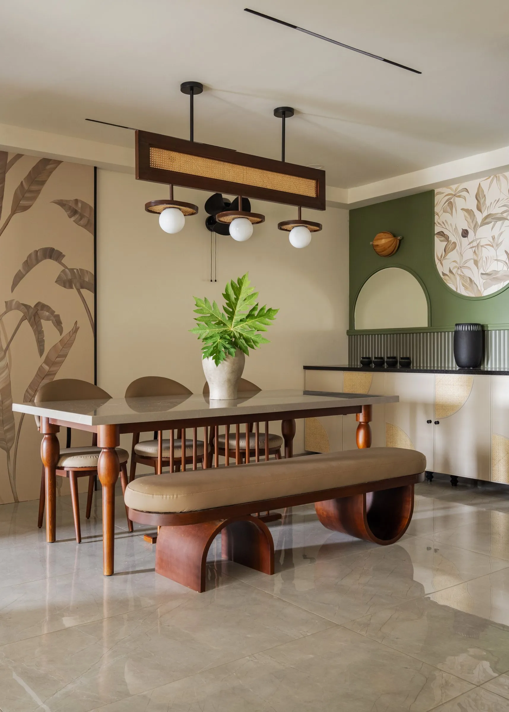 Hyrat dining room with a sculpted bench, palm wallpaper and a sage wall