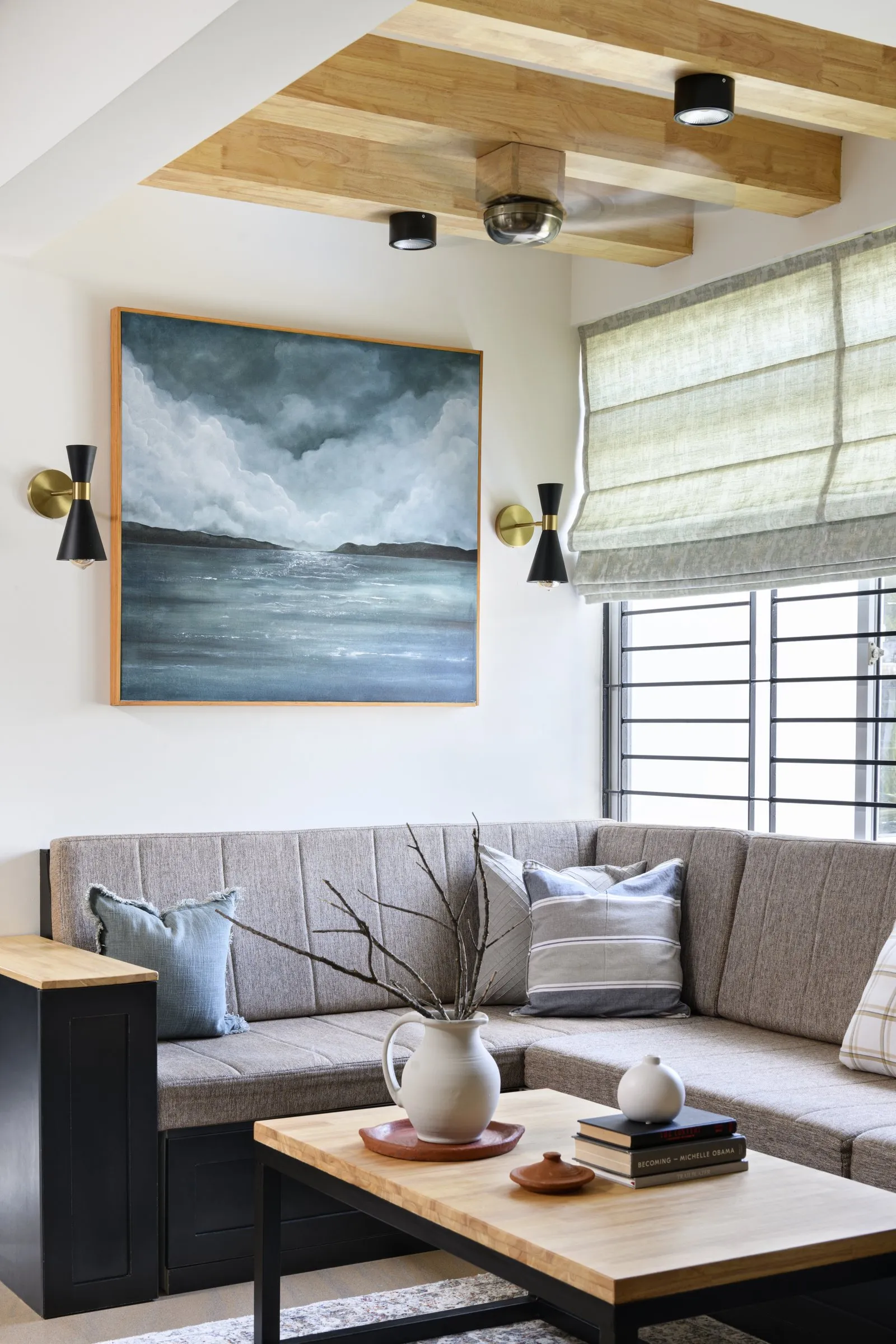 Corner sofa under a seascape painting and oak ceiling beams