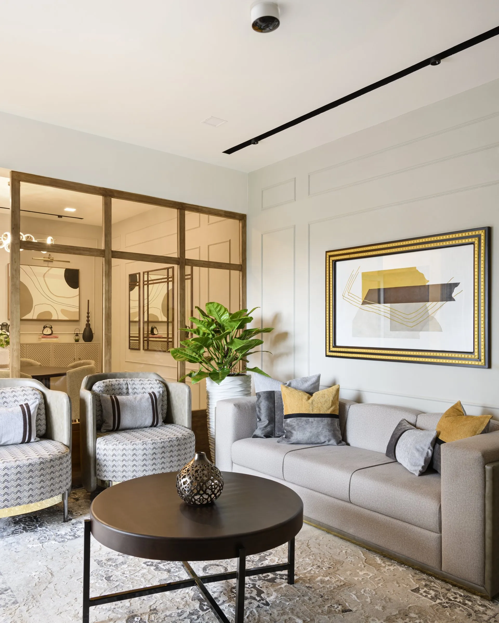 Living room with grey sofas, mustard cushions and a gold-framed painting