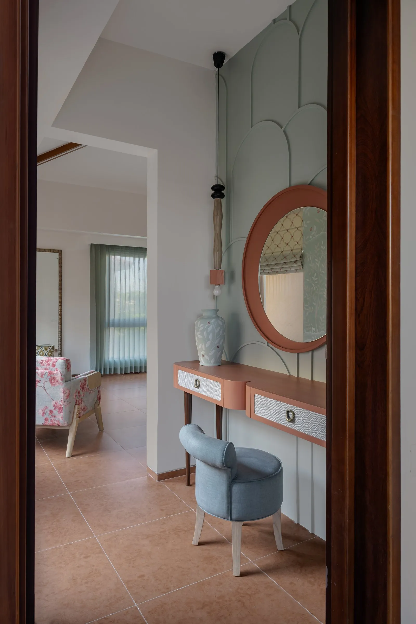 Dressing table with a round terracotta mirror and a blue stool