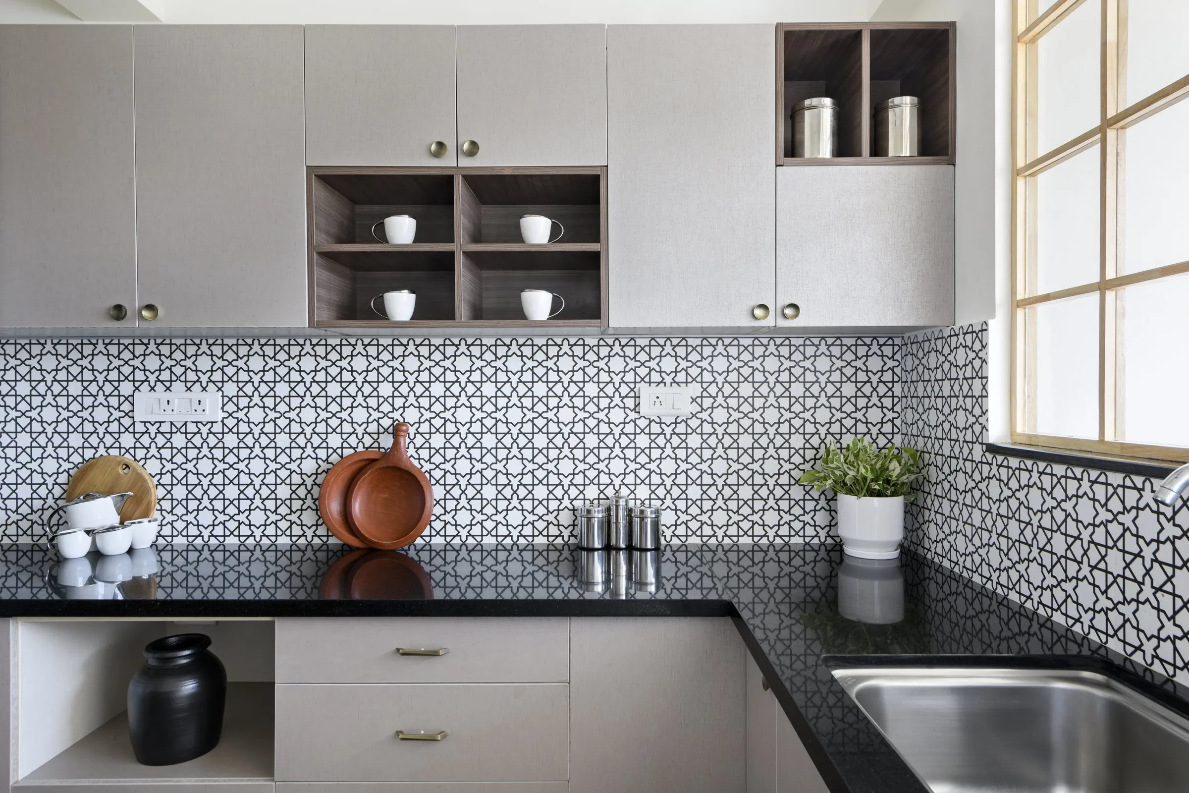 Patterned tiles with terracotta pots on a black counter