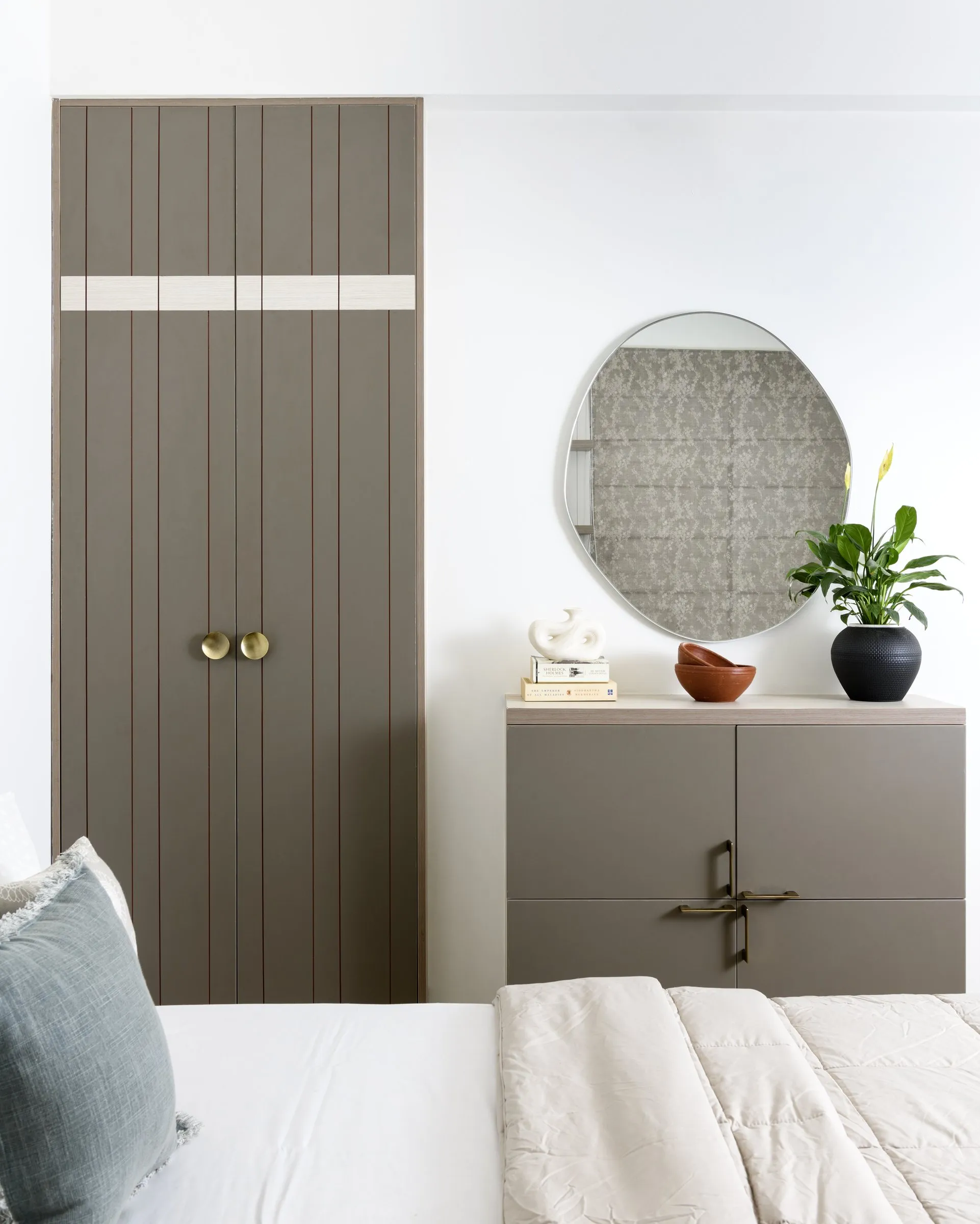 Taupe wardrobe with a round mirror and brass handles