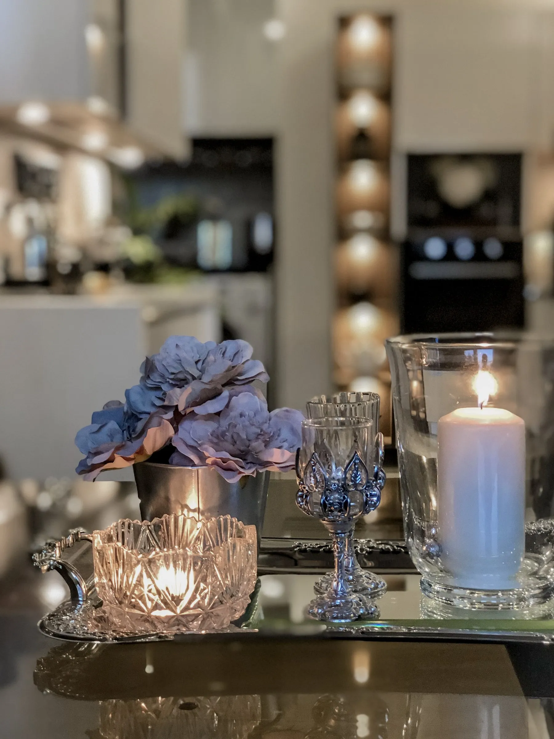 Candles and crystal glasses on a mirrored tray