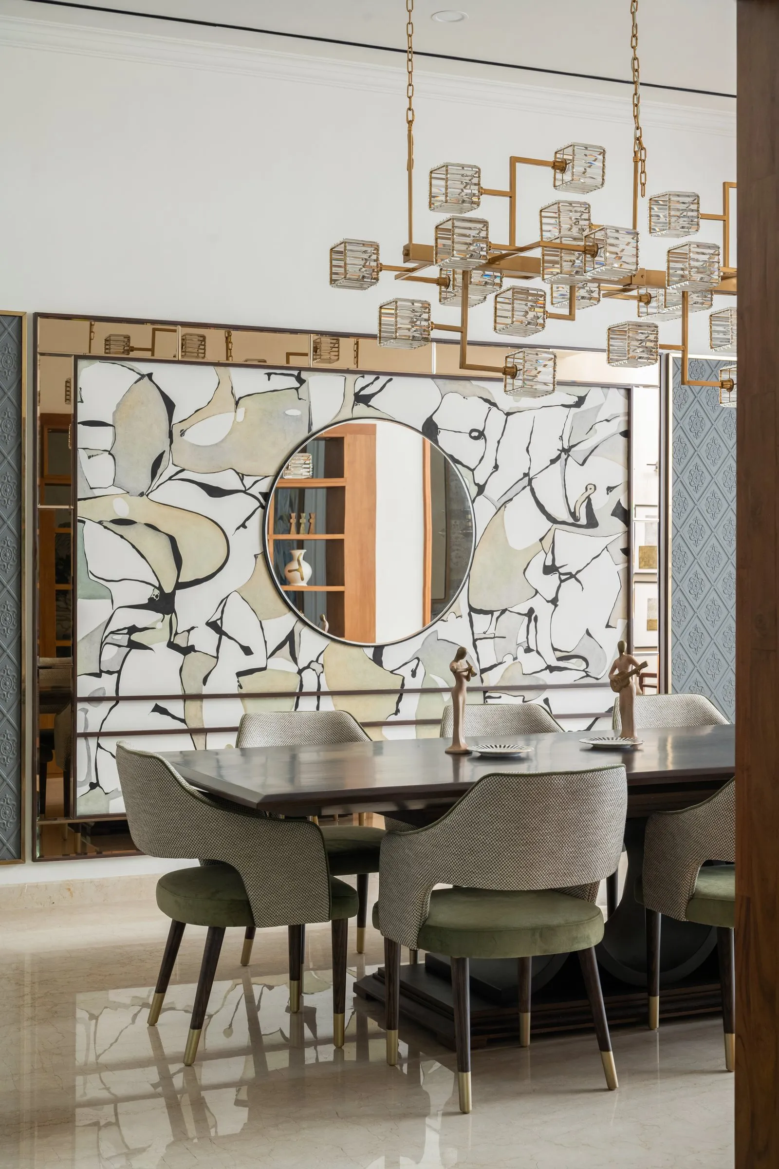 Dining room with a crystal chandelier and a painted glass screen
