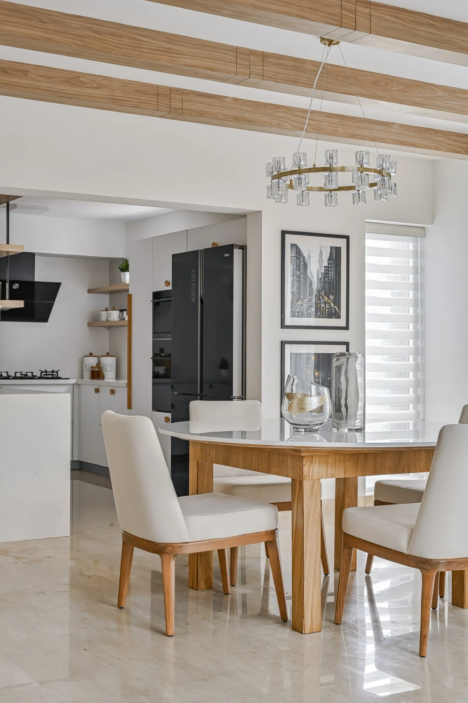 Round dining table with cream chairs under a ring chandelier