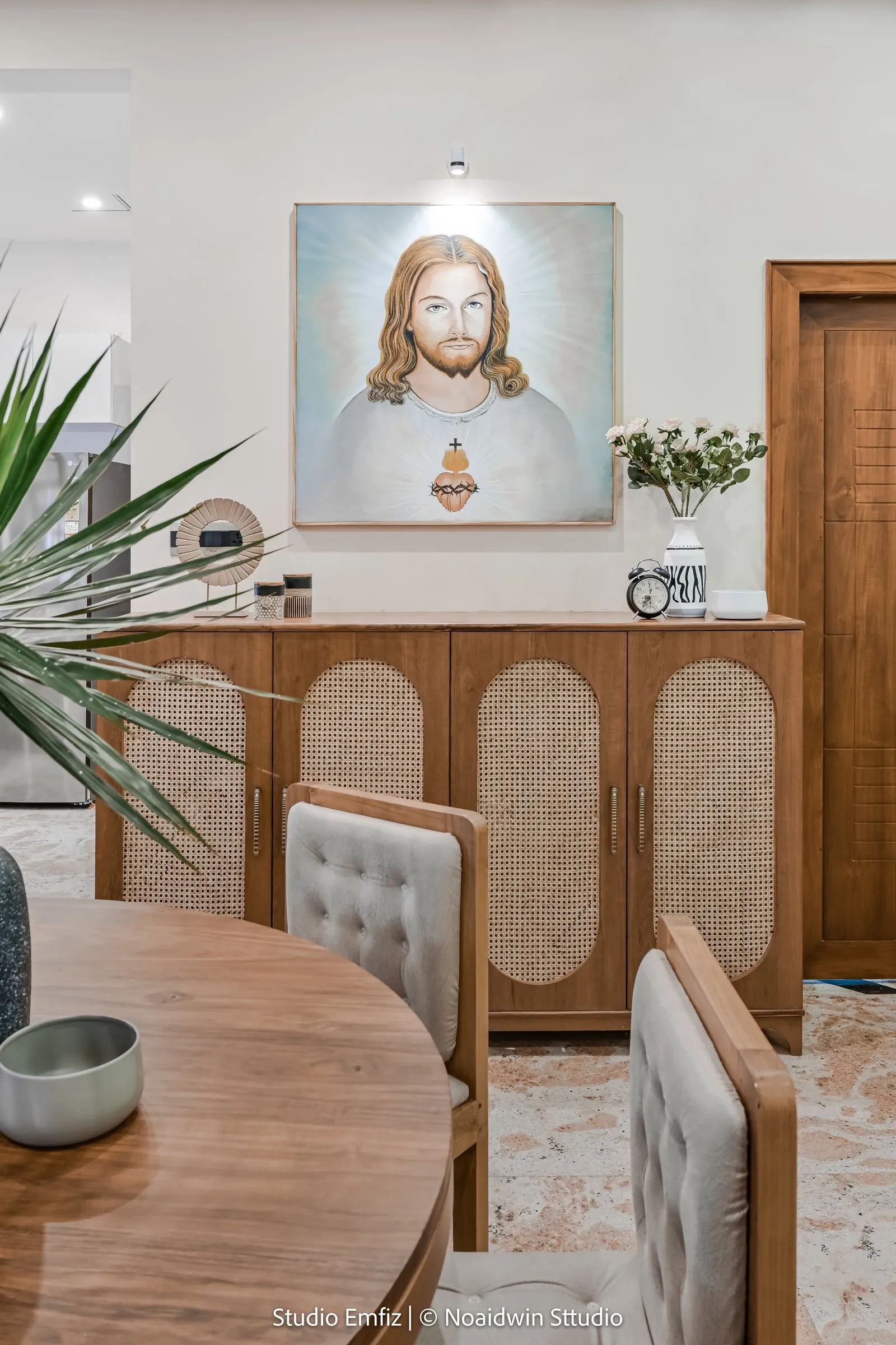 Dining table with a cane-front cabinet and a framed painting