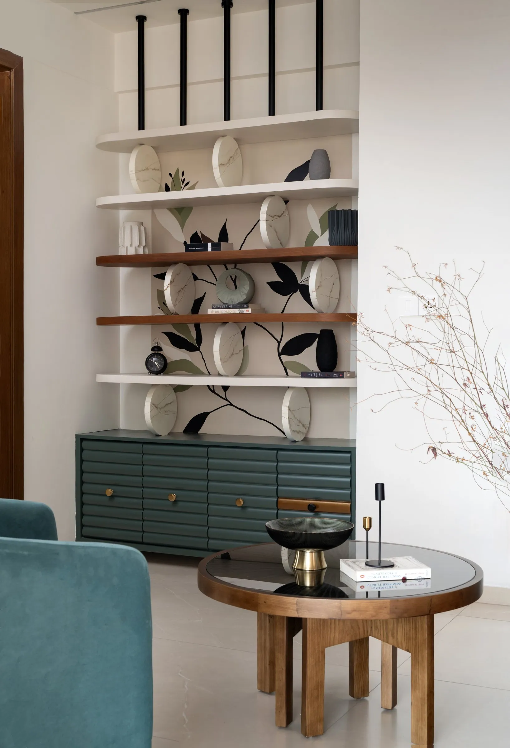 Open shelf with painted leaves above a teal cabinet