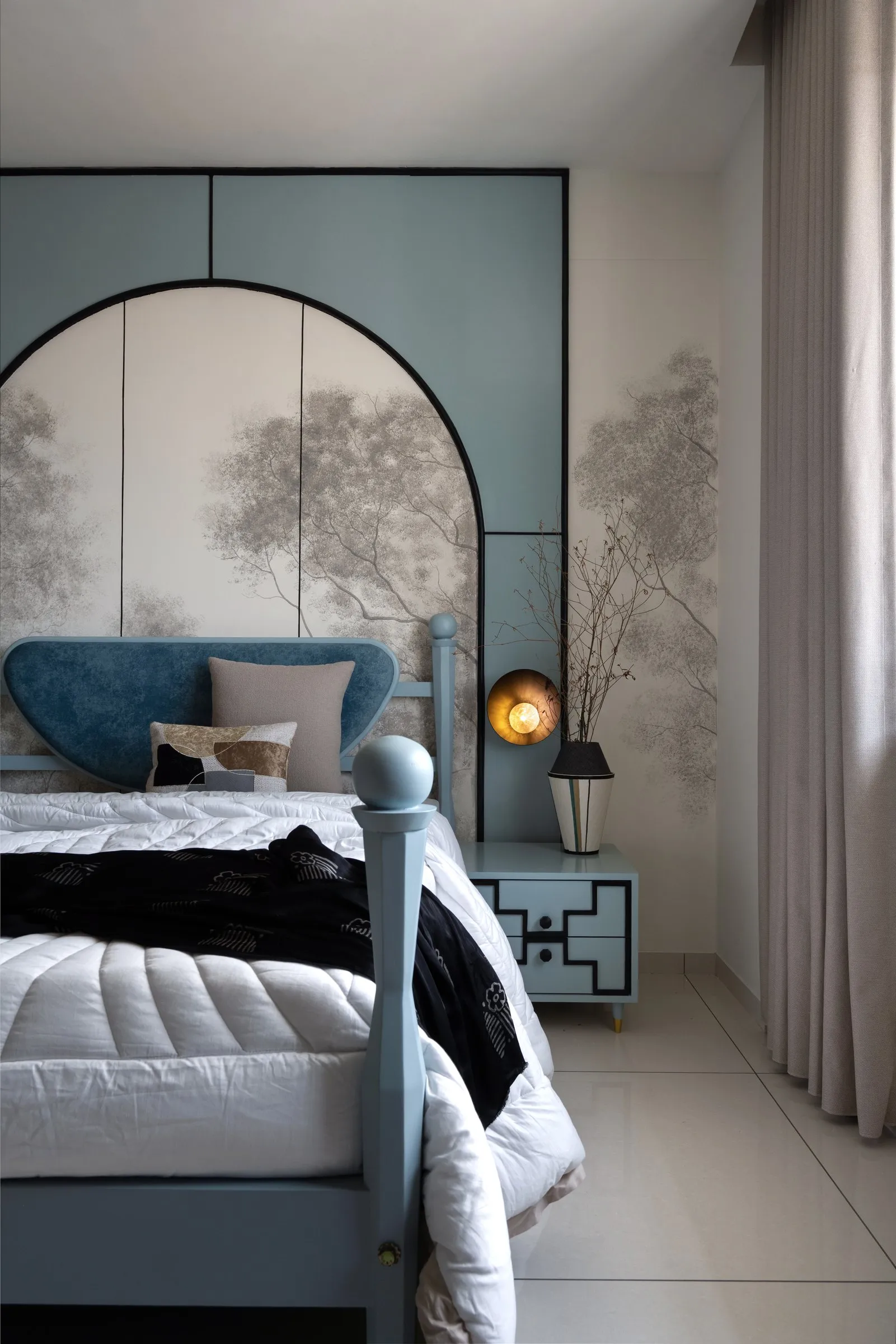 Blue velvet headboard in front of a painted forest mural