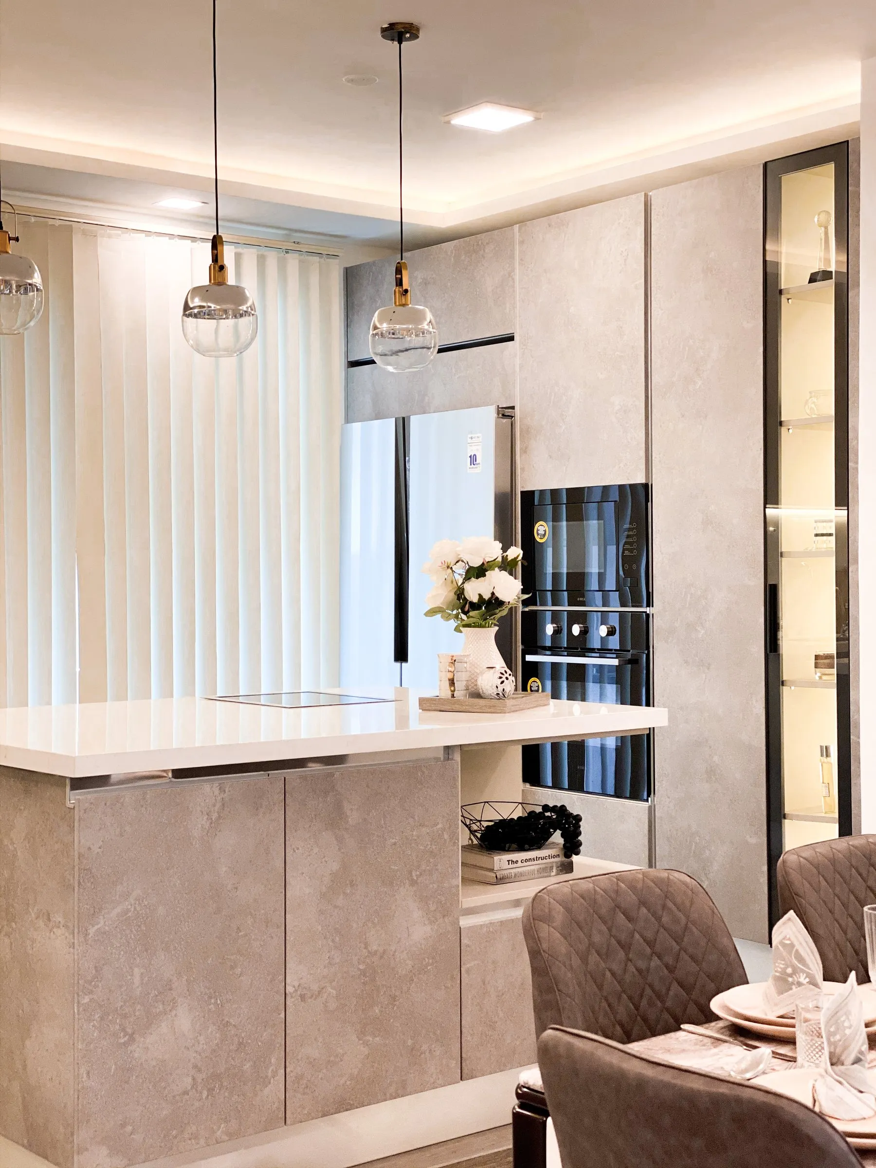 Kitchen island with glass pendant lights and velvet dining chairs