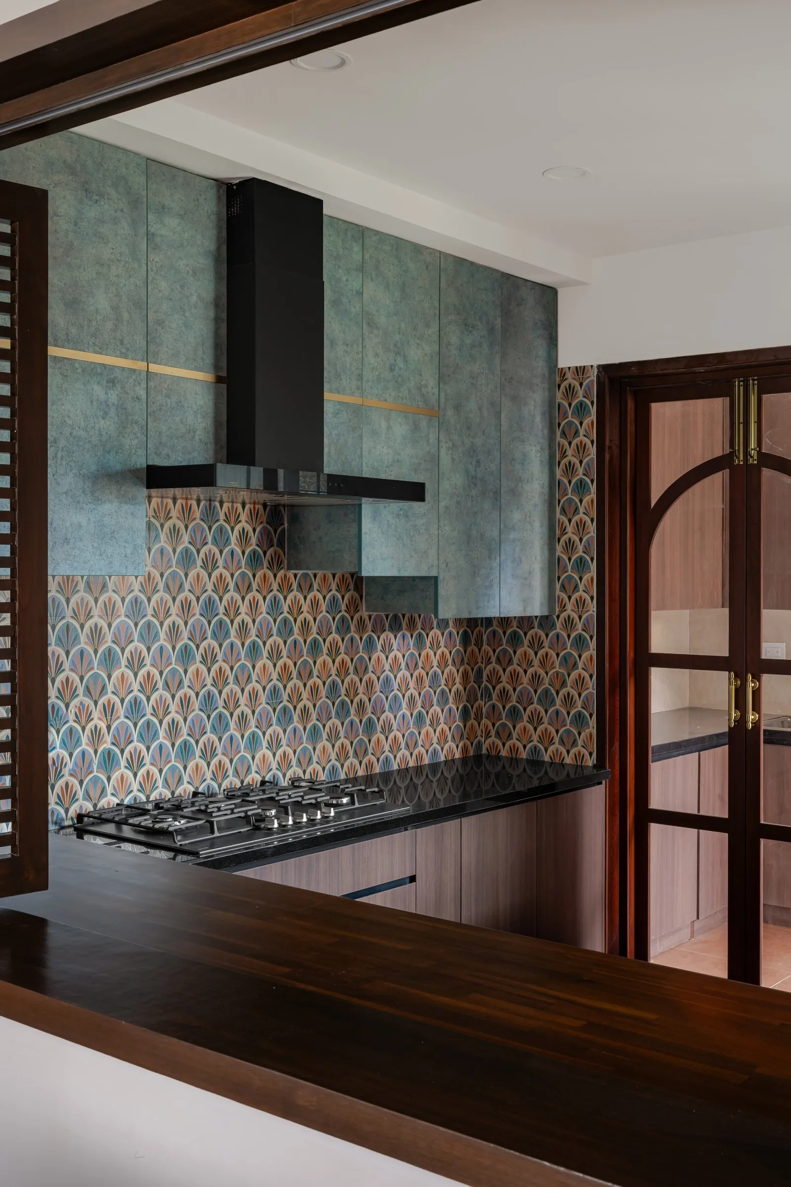 Kitchen seen through a serving hatch with a wooden counter
