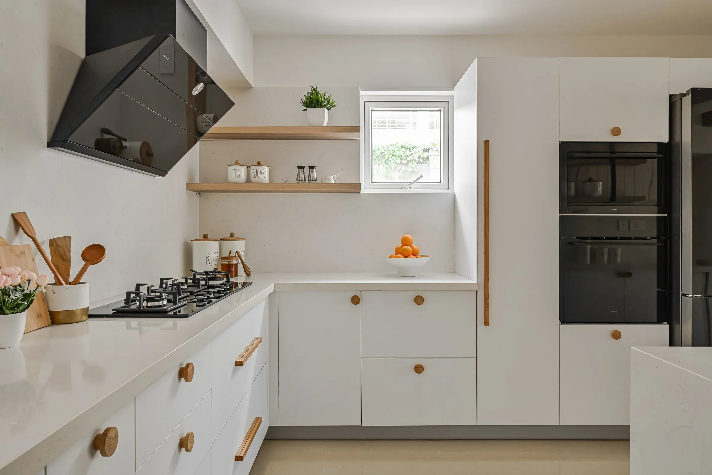 Kitchen with a black angled hood and oak floating shelves