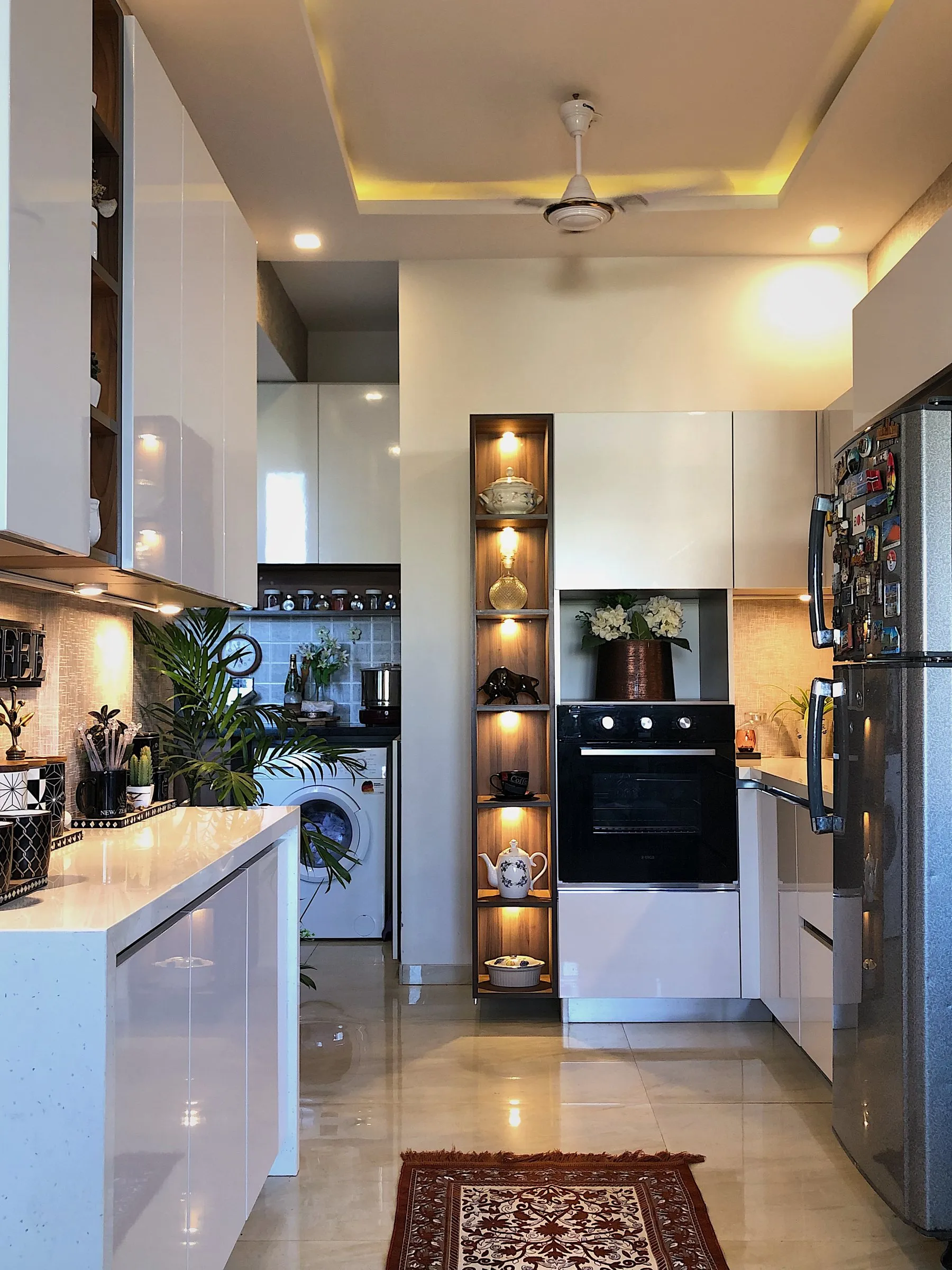Kitchen with lit open shelves and a patterned rug