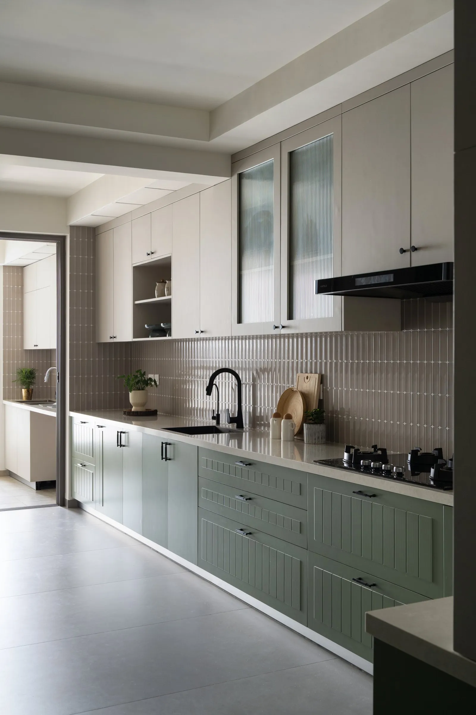 Kitchen counter with a black tap and warm grey tiles