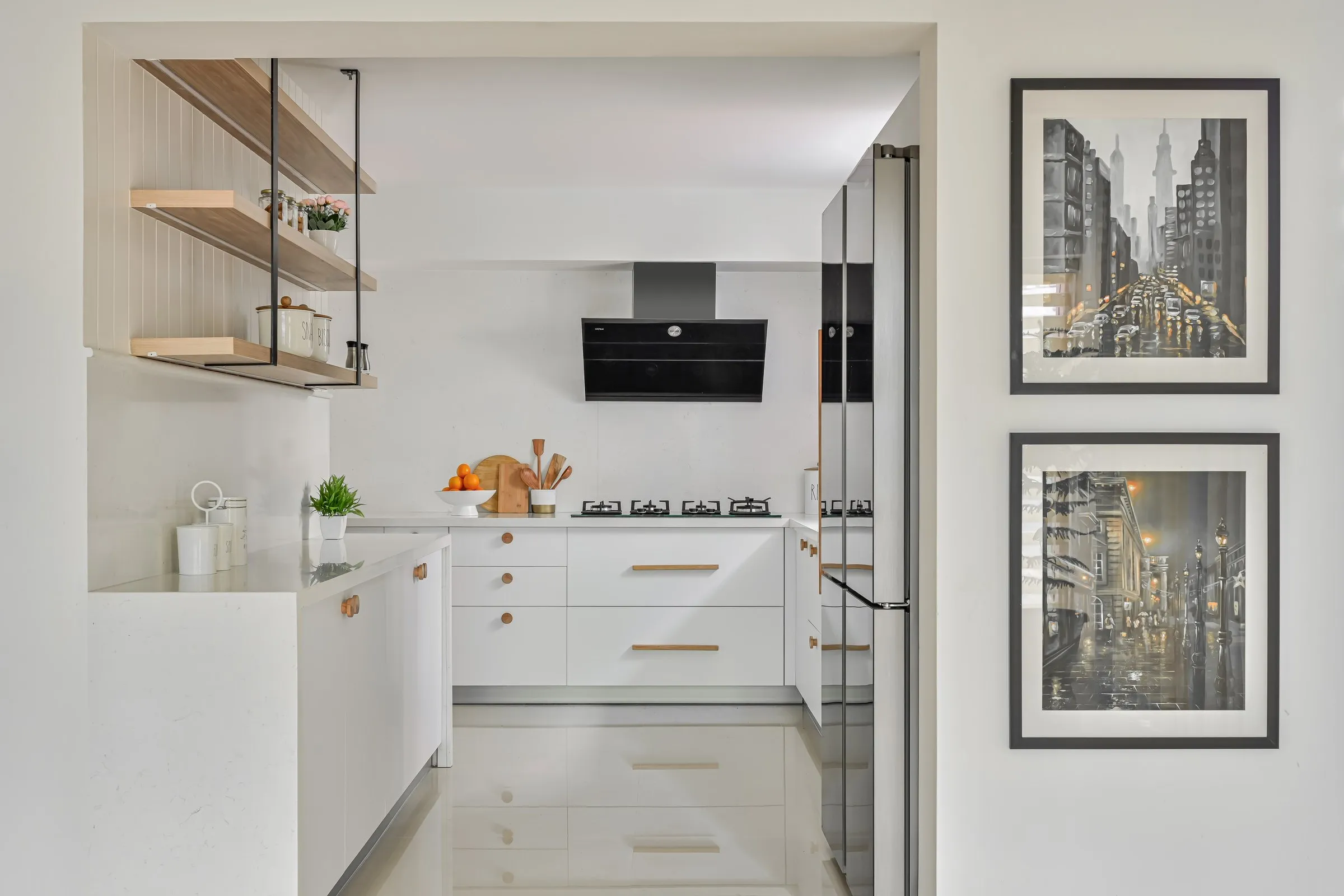 Kitchen framed by the doorway with city prints on the wall