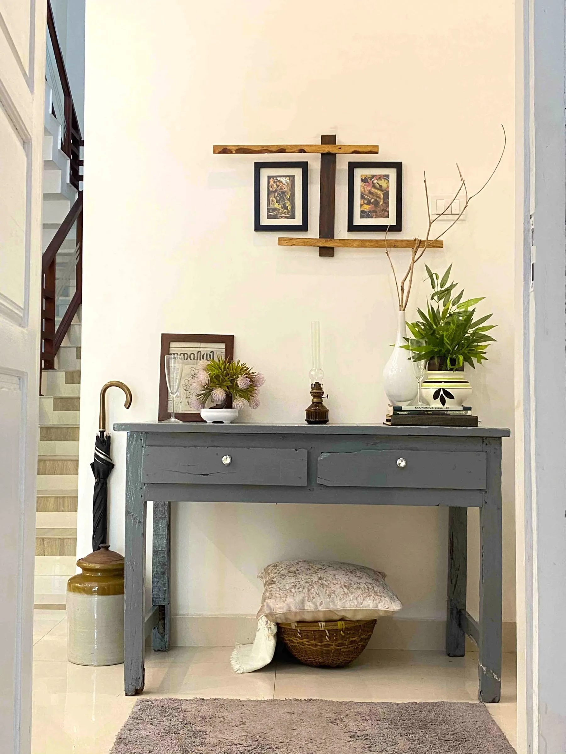 Grey painted console with framed prints by the stairs