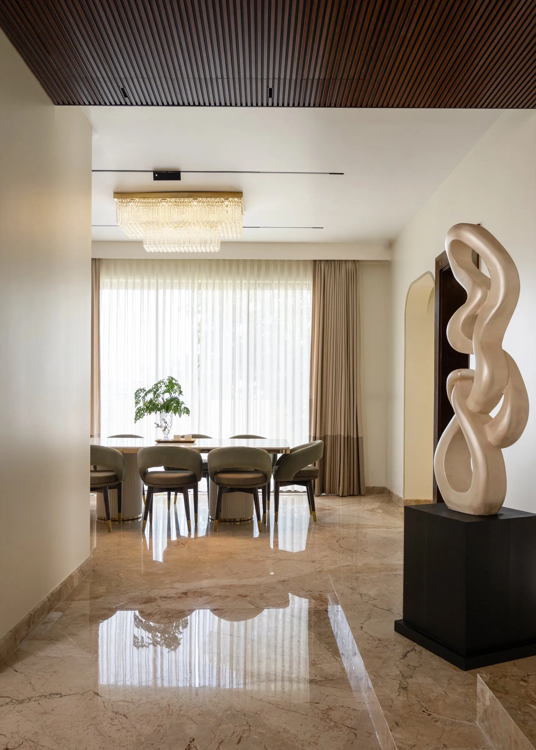Entrance with a carved sculpture and a view through to the dining room