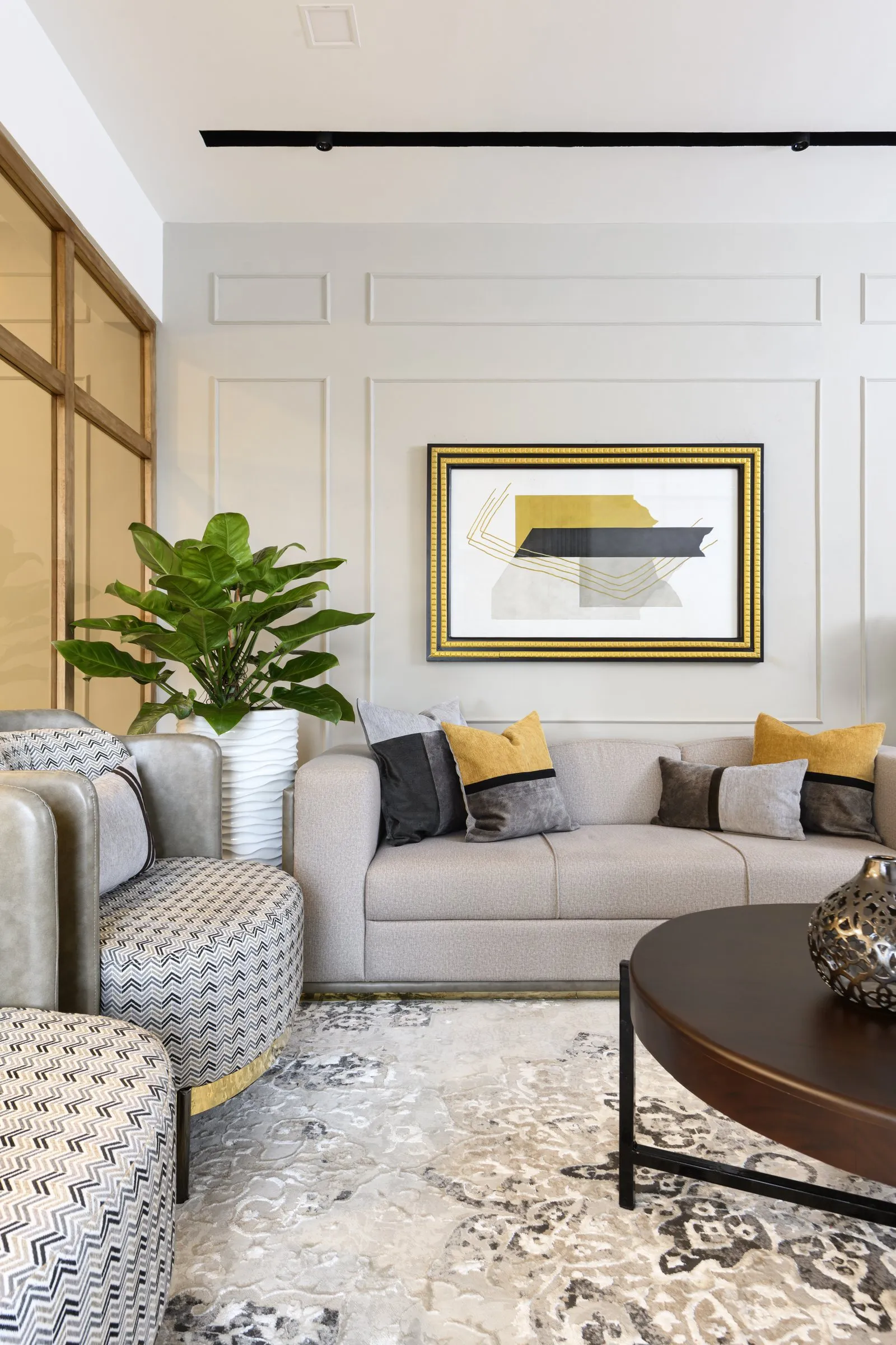 Living room with patterned armchairs and a gold-framed painting