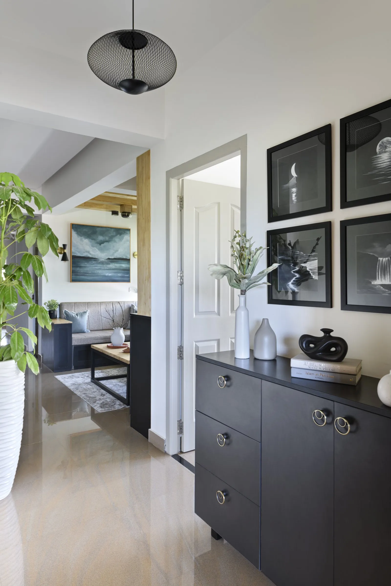 Hallway with a black chest of drawers and framed monochrome prints