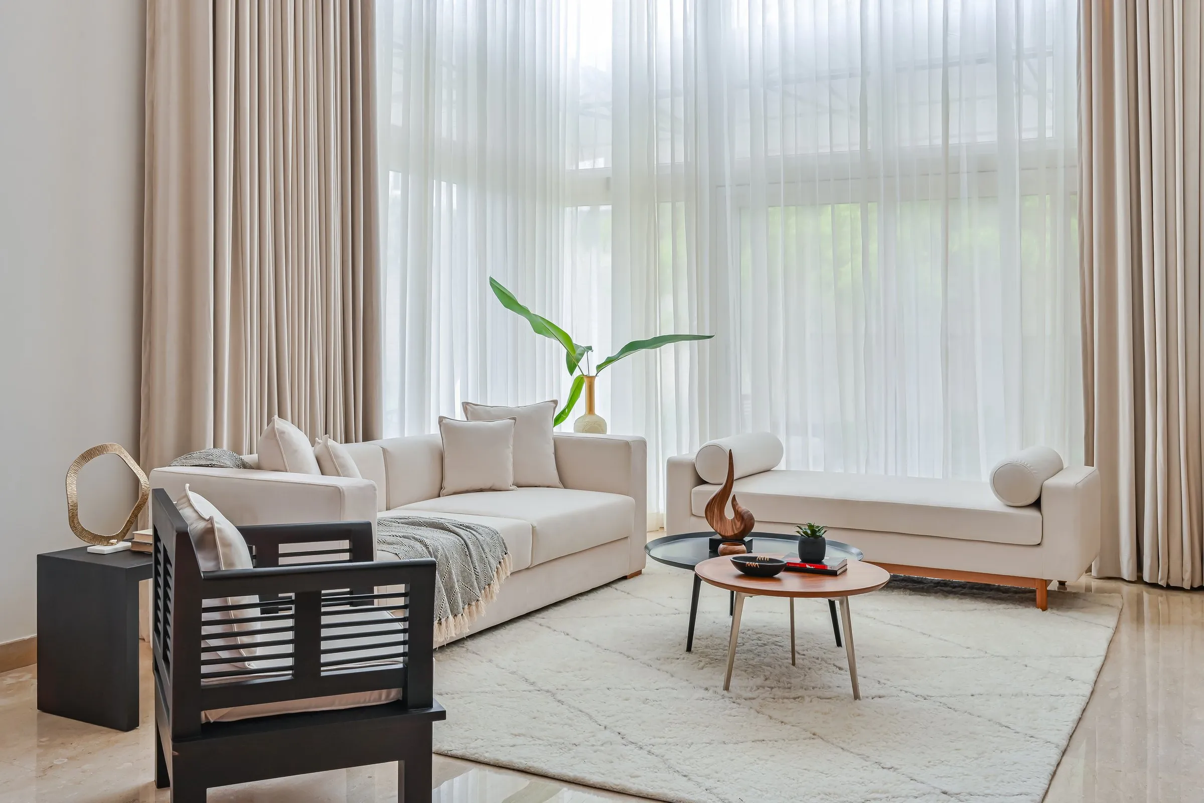 Living room with white sofas in front of tall sheer curtains