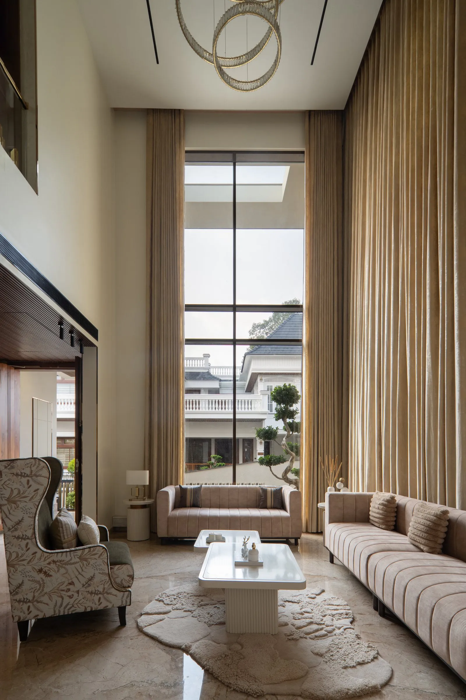 Double-height living room with gold ring lights and a tall window
