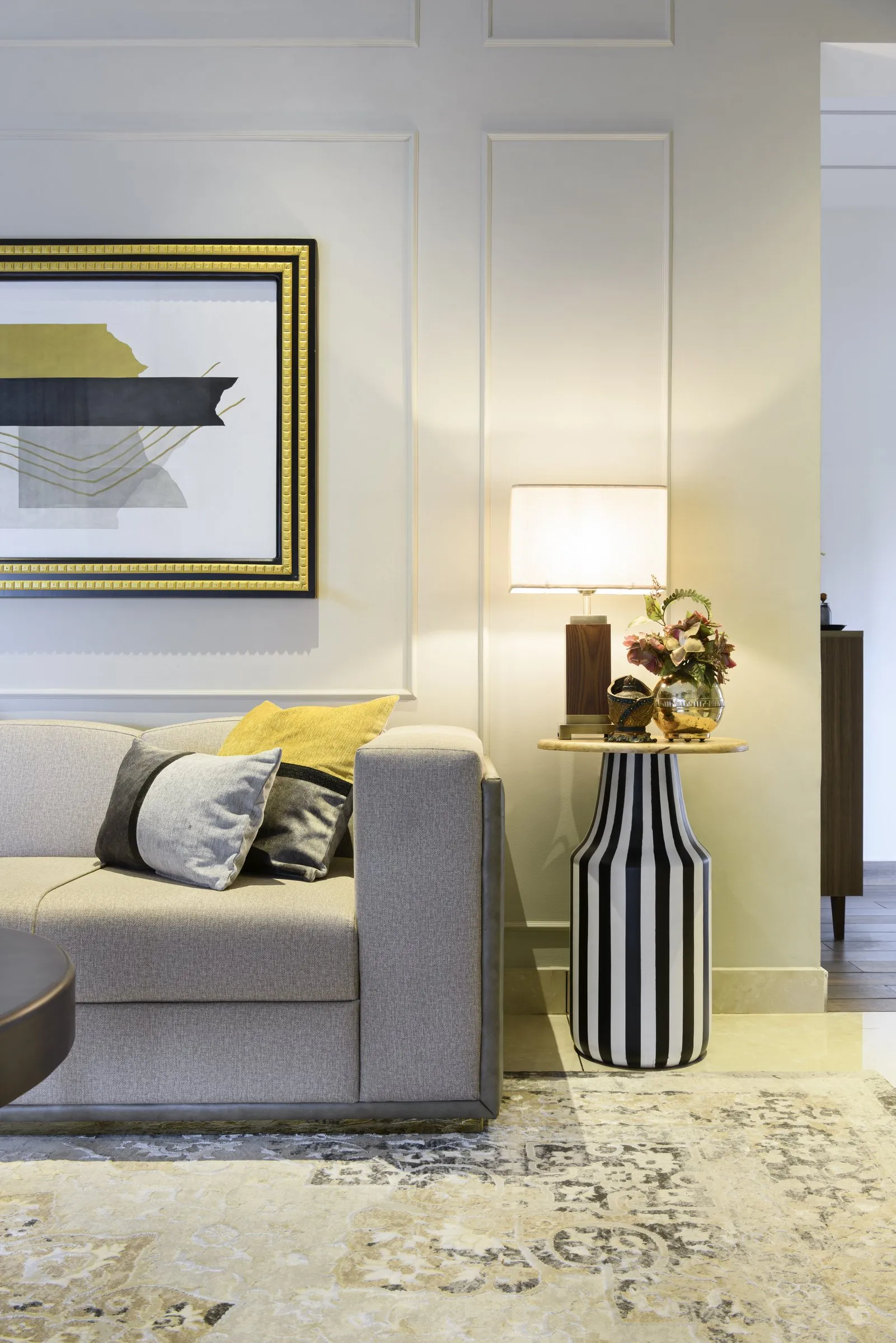 Grey sofa beside a striped lamp table