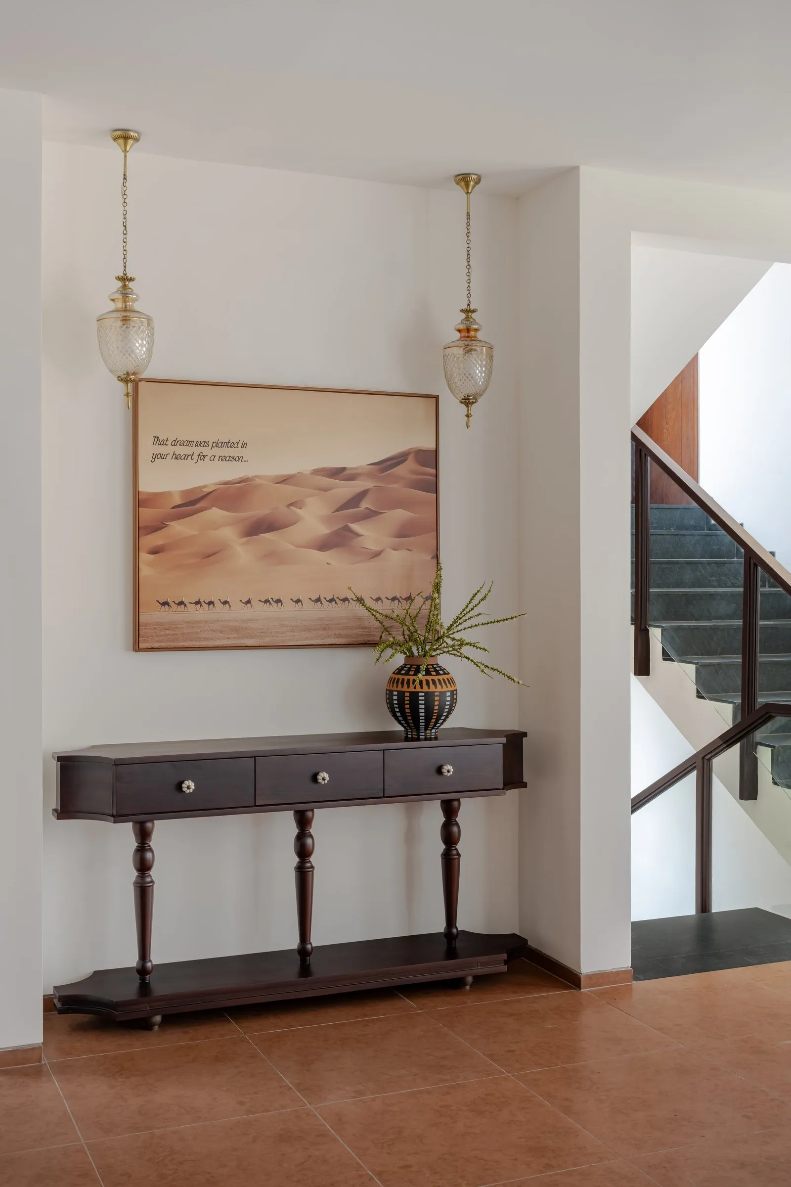 Hall console with a desert print and glass pendant lamps
