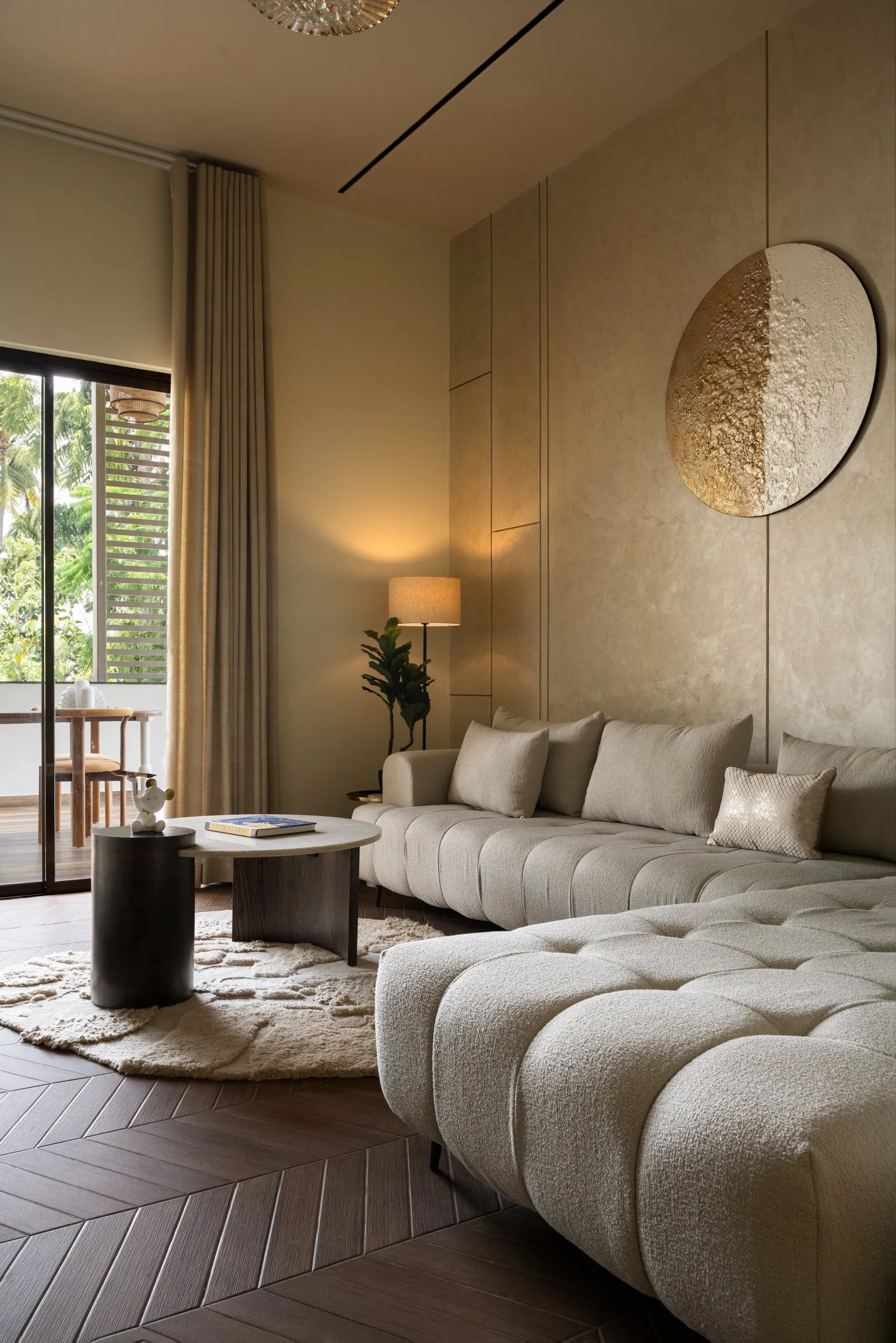 Family lounge with a cream boucle sofa and a gold moon wall piece