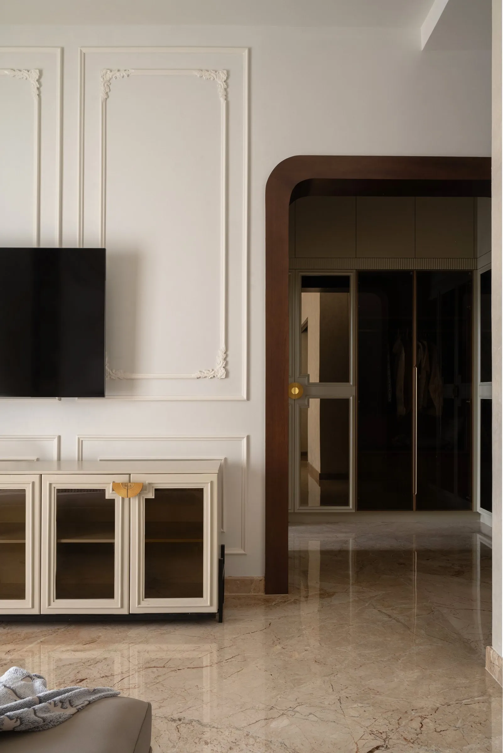White panelled TV wall with a gold-trimmed cabinet