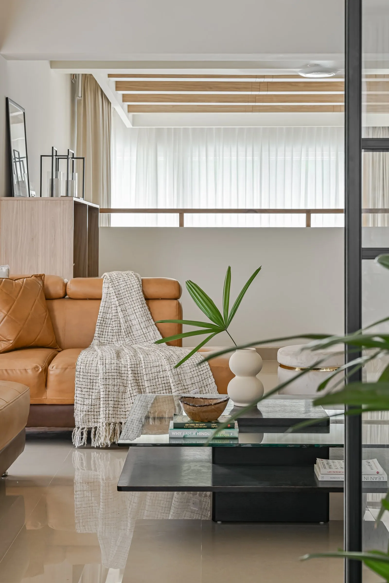 Leather sofa with a woven throw and a glass coffee table