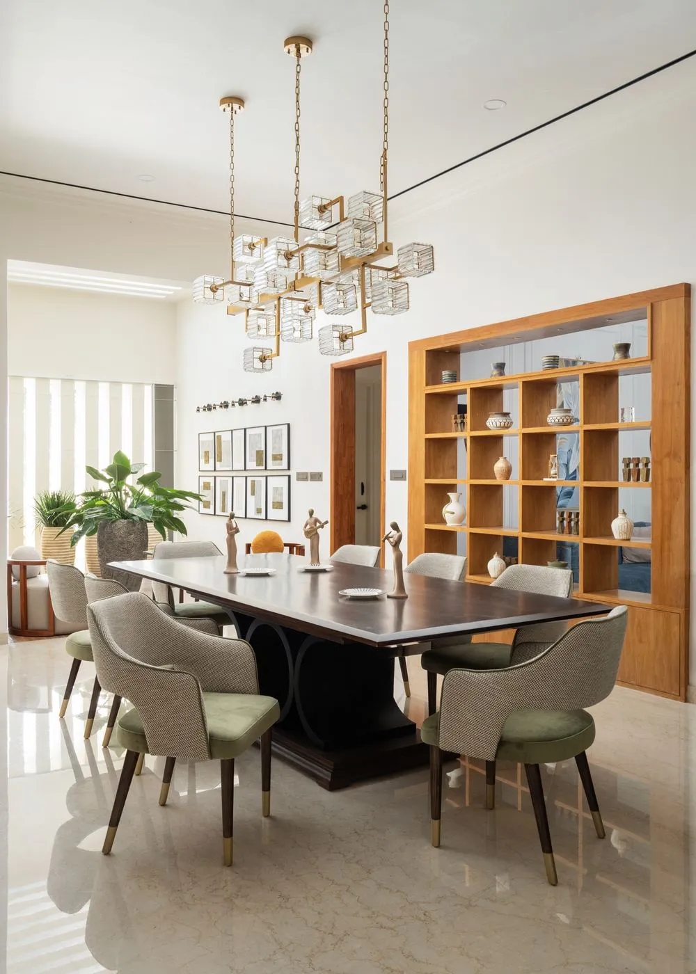 Dining room with brass chandelier and walnut shelving